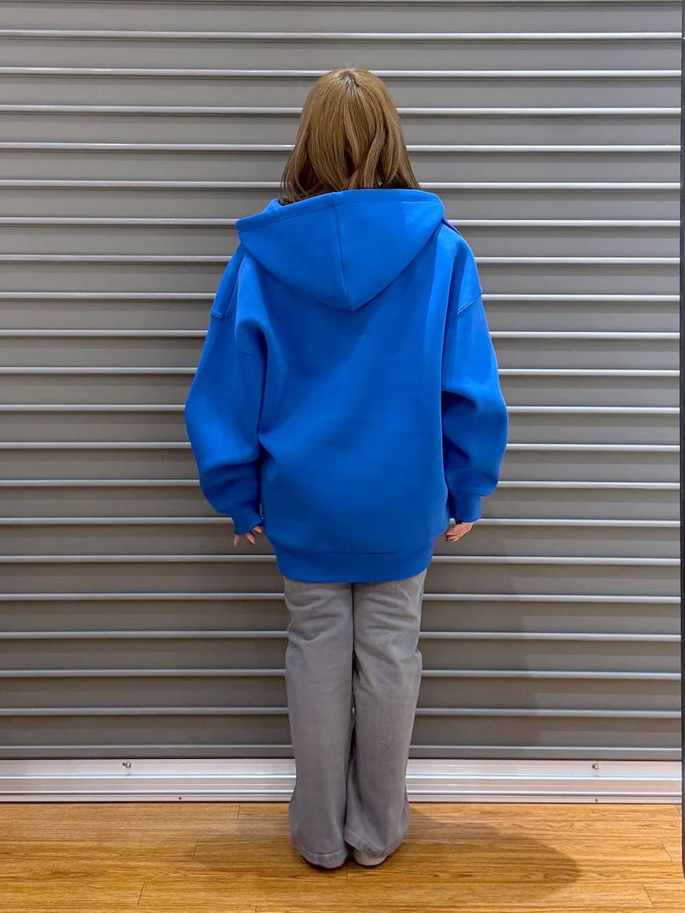 ブルー系のパーカー、ブラック系のTシャツ/カットソー、シルバー系のパンプスを着用したレディースの春コーディネートの2枚目の写真