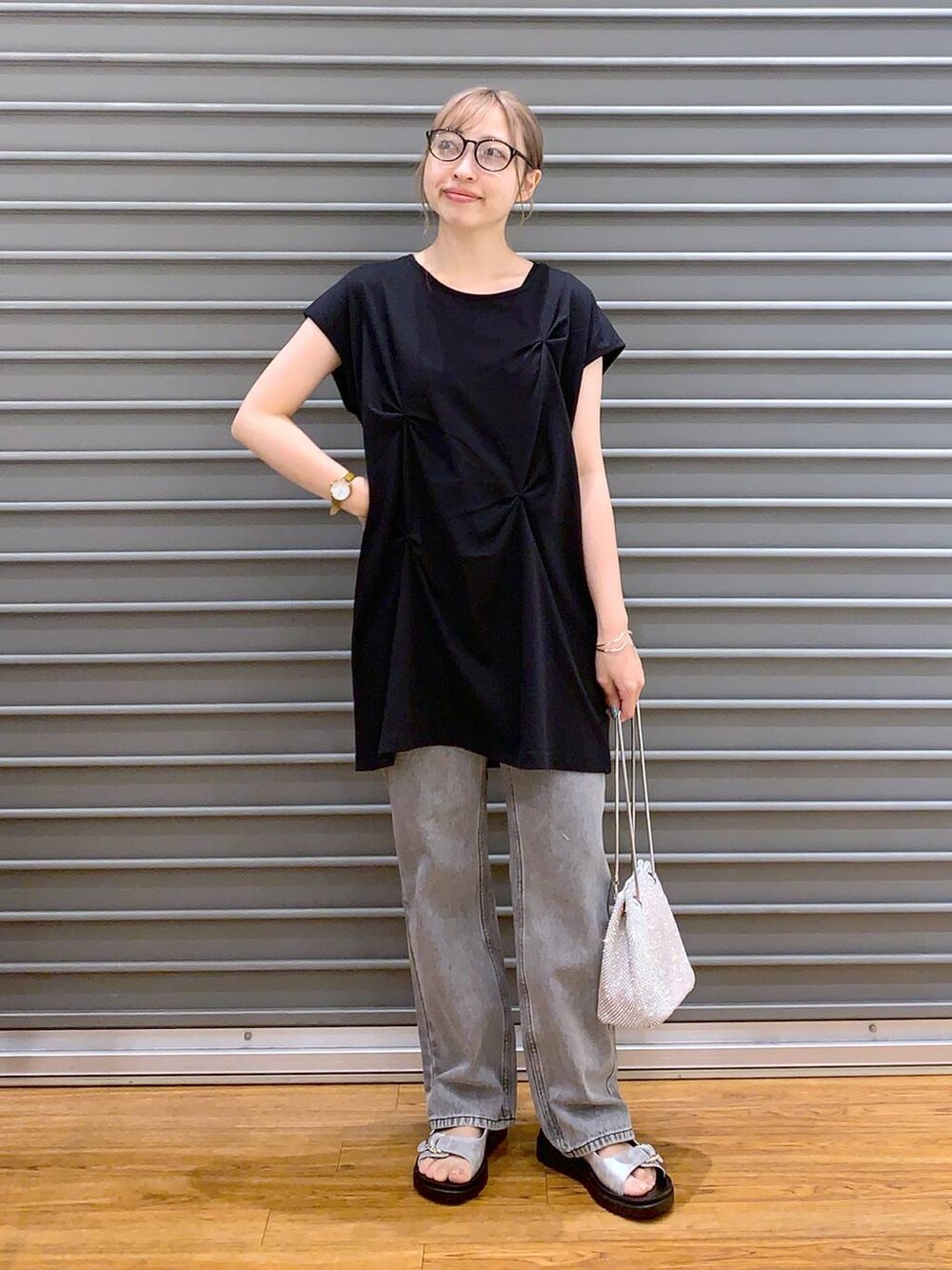 ホワイト系のショルダーバッグ、シルバー系のサンダル、グレー系のデニムパンツを着用したレディースの夏コーディネートの6枚目の写真