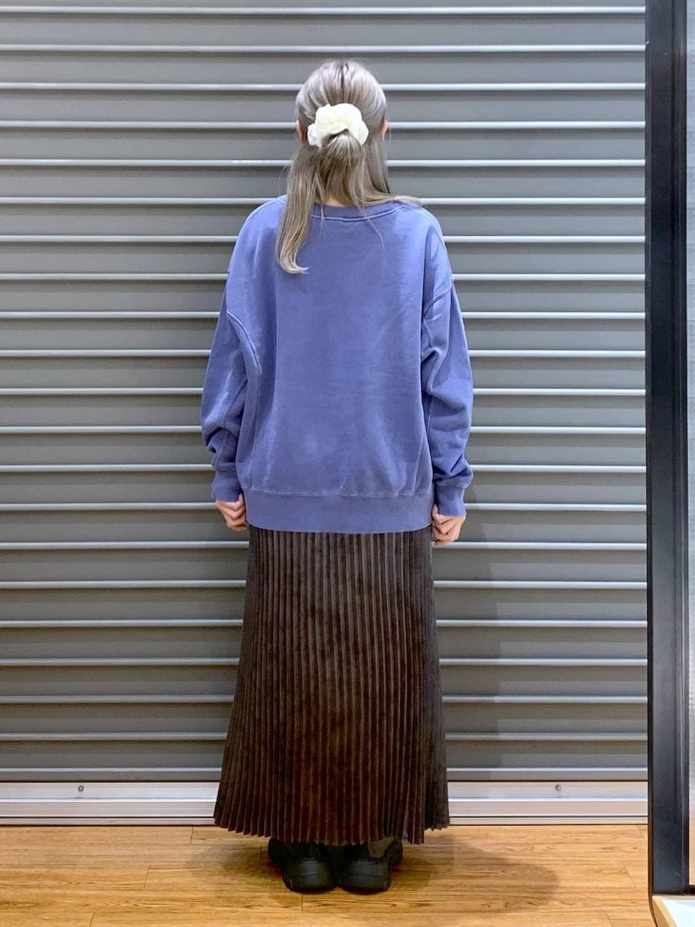 グレー系のショルダーバッグ、ブラック系のスニーカー、グレー系のスカートを着用したレディースの秋コーディネートの2枚目の写真