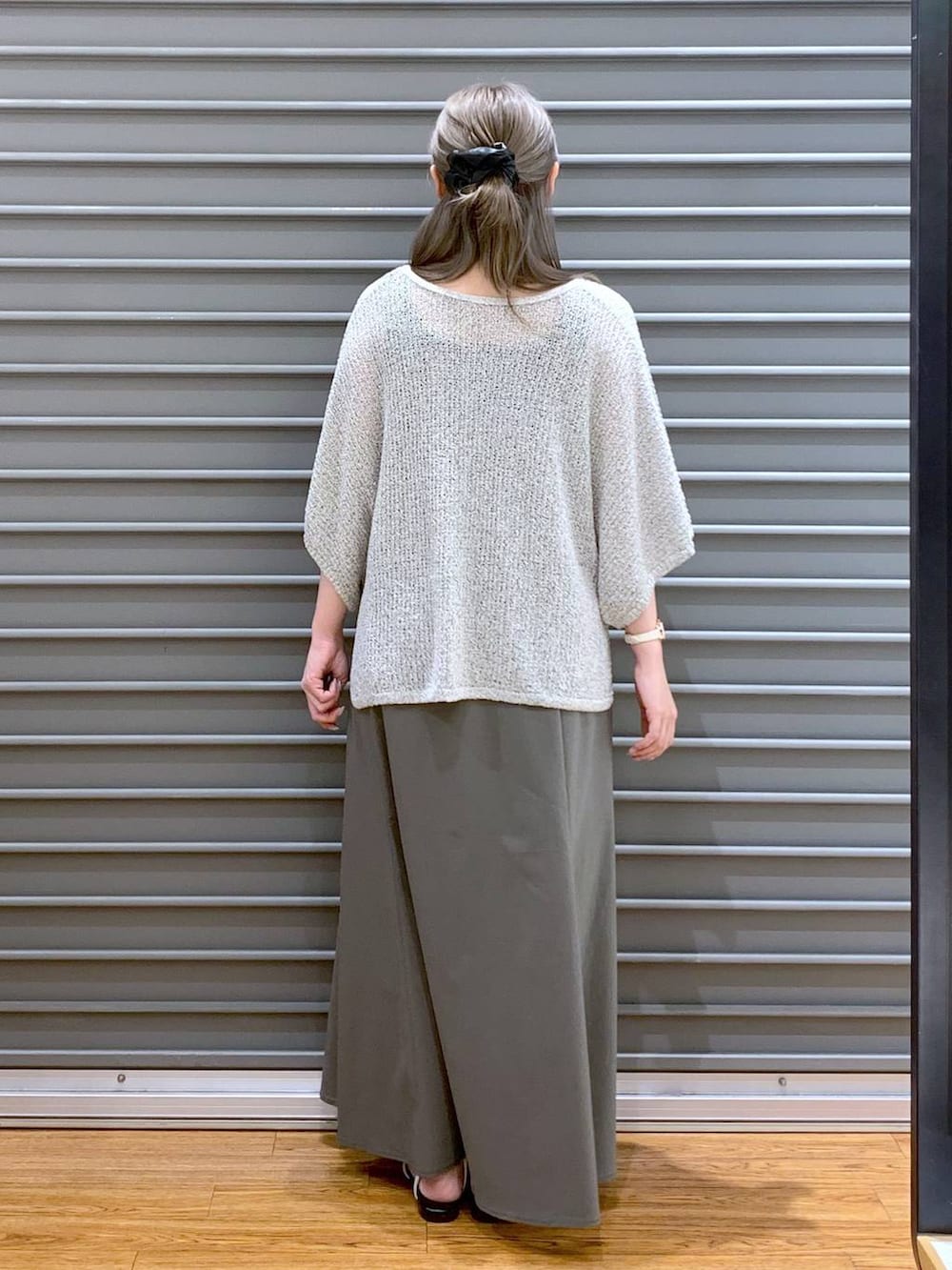 ベージュ系のニット/セーター、ホワイト系のサンダル、ベージュ系のトートバッグを着用したレディースの夏コーディネートの2枚目の写真