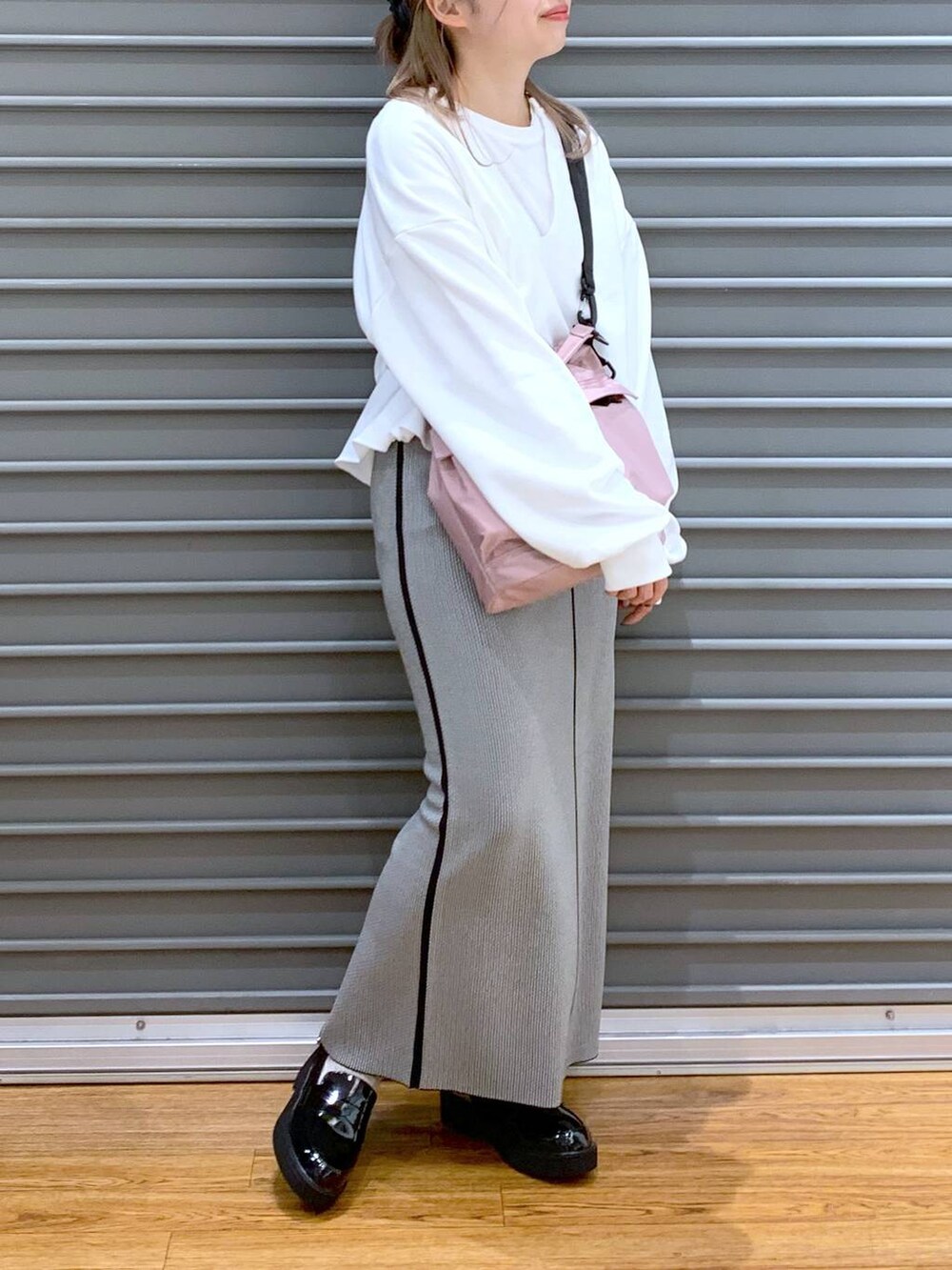 ピンク系のショルダーバッグ、ブラック系のローファー、ブラック系のスカートを着用したレディースの春コーディネートの5枚目の写真