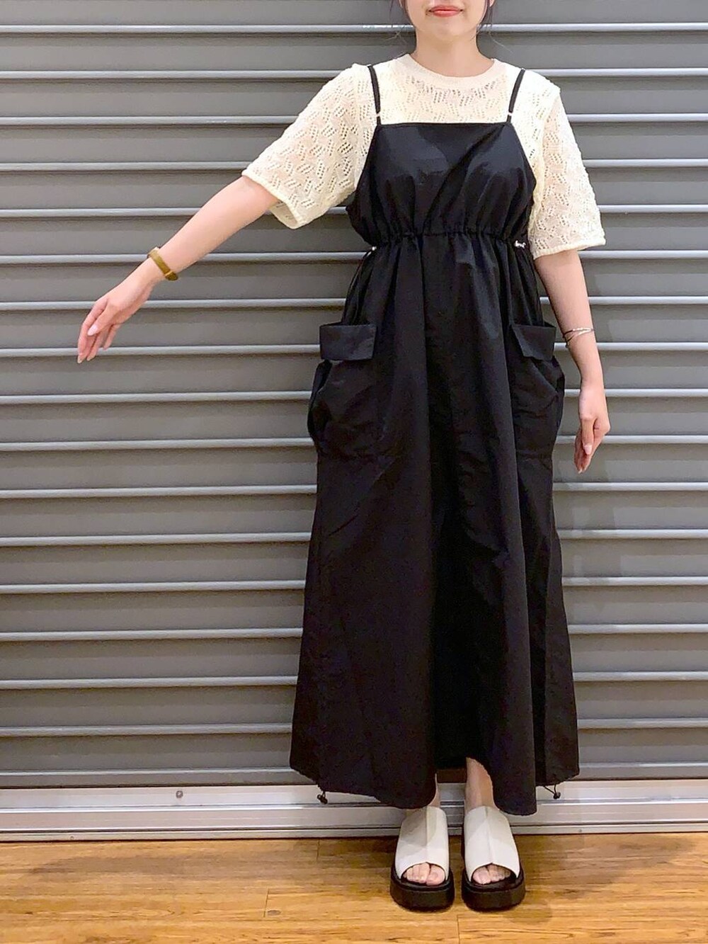 ブラック系のショルダーバッグ、ブラック系のワンピース、ホワイト系のサンダルを着用したレディースの春コーディネートの3枚目の写真