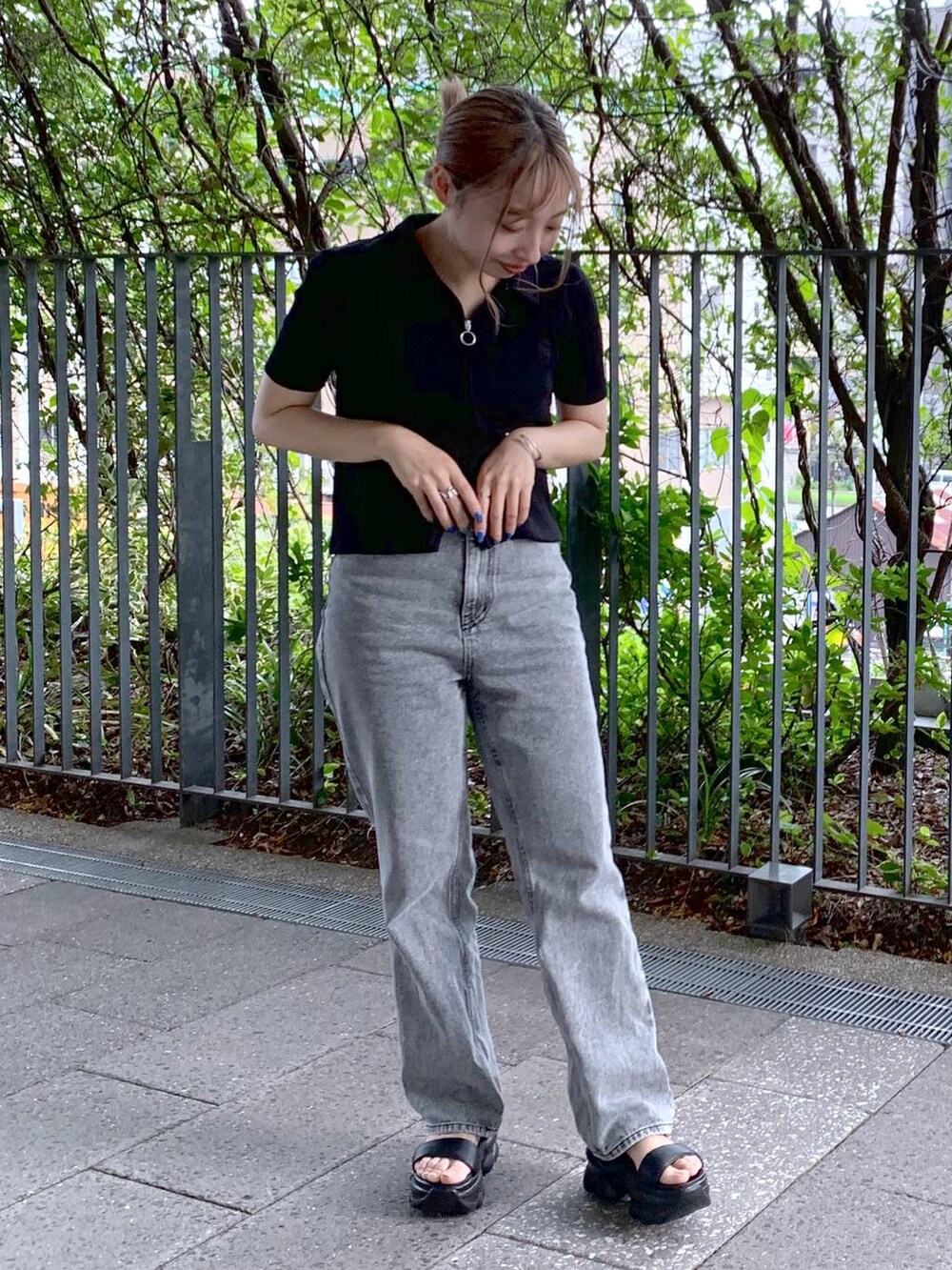 ブラック系のショルダーバッグ、ブラック系のサンダル、グレー系のデニムパンツを着用したレディースの夏コーディネートの6枚目の写真