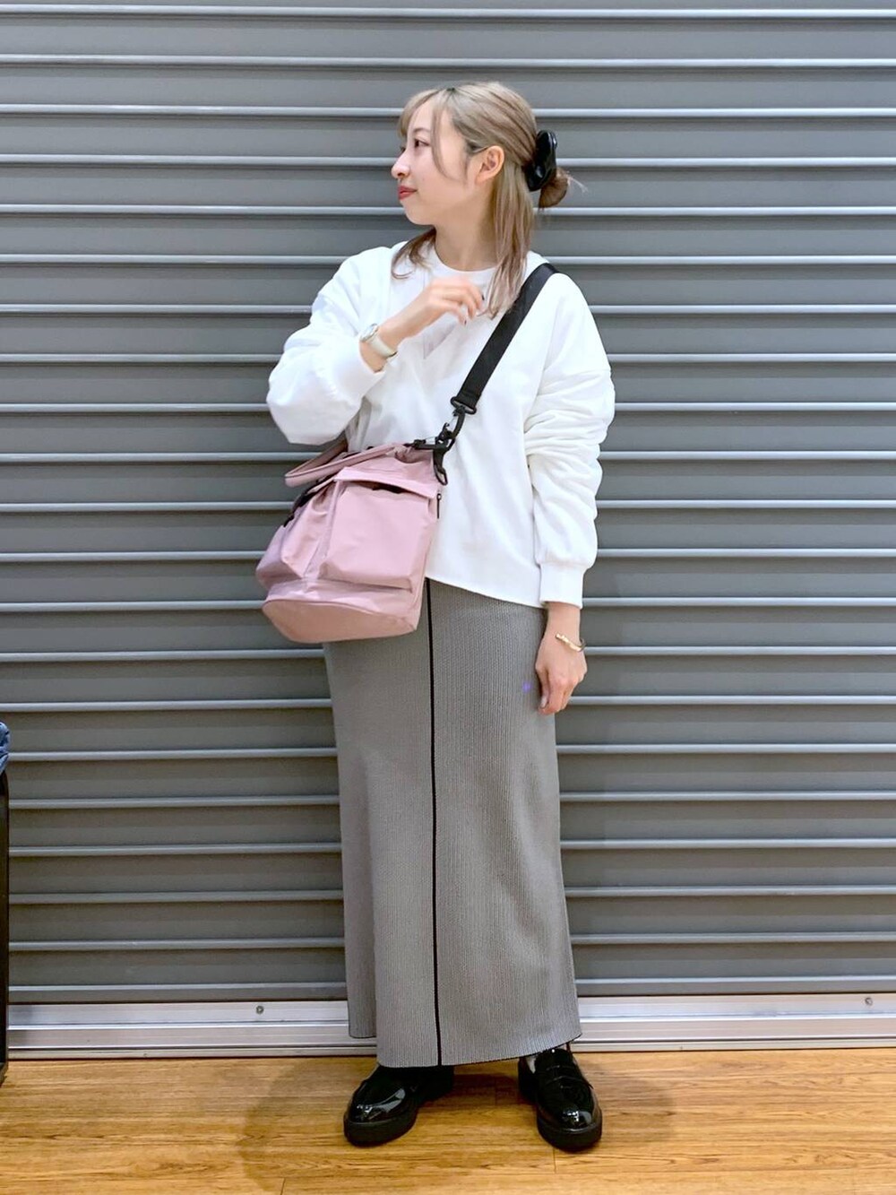 ピンク系のショルダーバッグ、ブラック系のローファー、ブラック系のスカートを着用したレディースの春コーディネートの4枚目の写真