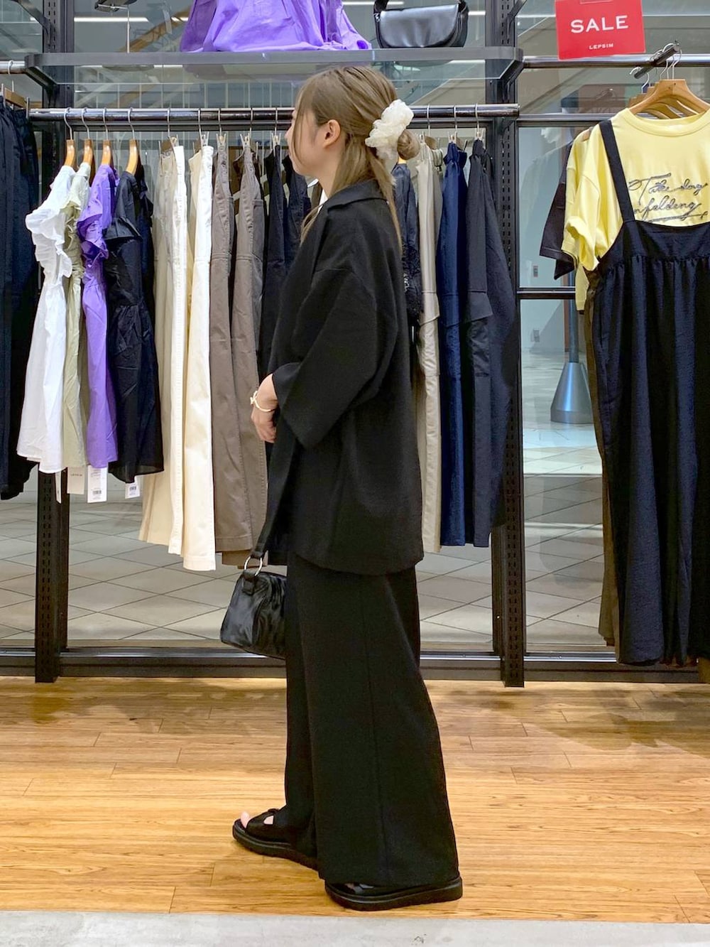 ブラック系のテーラードジャケット、ブルー系のタンクトップ、ブラック系のサンダルを着用したレディースの夏コーディネートの3枚目の写真