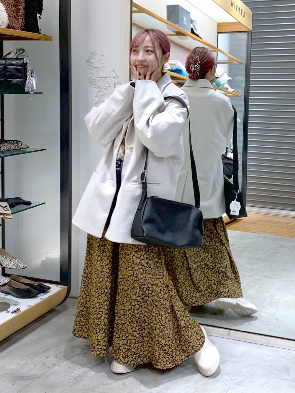 ホワイト系のその他アウター、ホワイト系のブーツ、ブラック系のショルダーバッグを着用したレディースの冬コーディネートの5枚目の写真