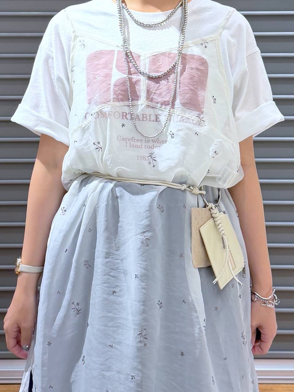 ホワイト系のワンピース、ホワイト系のTシャツ/カットソー、ホワイト系のサンダルを着用したレディースの夏コーディネートの4枚目の写真