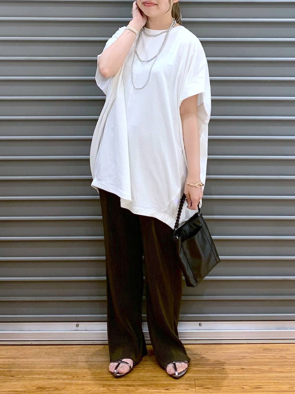 その他のサンダル、ブラウン系のその他パンツ、ブラック系のショルダーバッグを着用したレディースの夏コーディネートの5枚目の写真