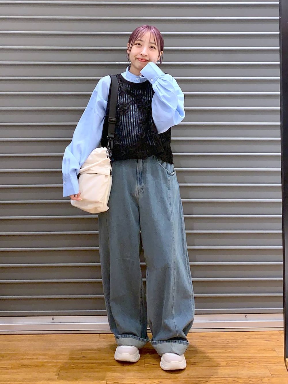 ホワイト系のショルダーバッグ、ブルー系のデニムパンツ、ホワイト系のスニーカーを着用したレディースの秋コーディネートの6枚目の写真