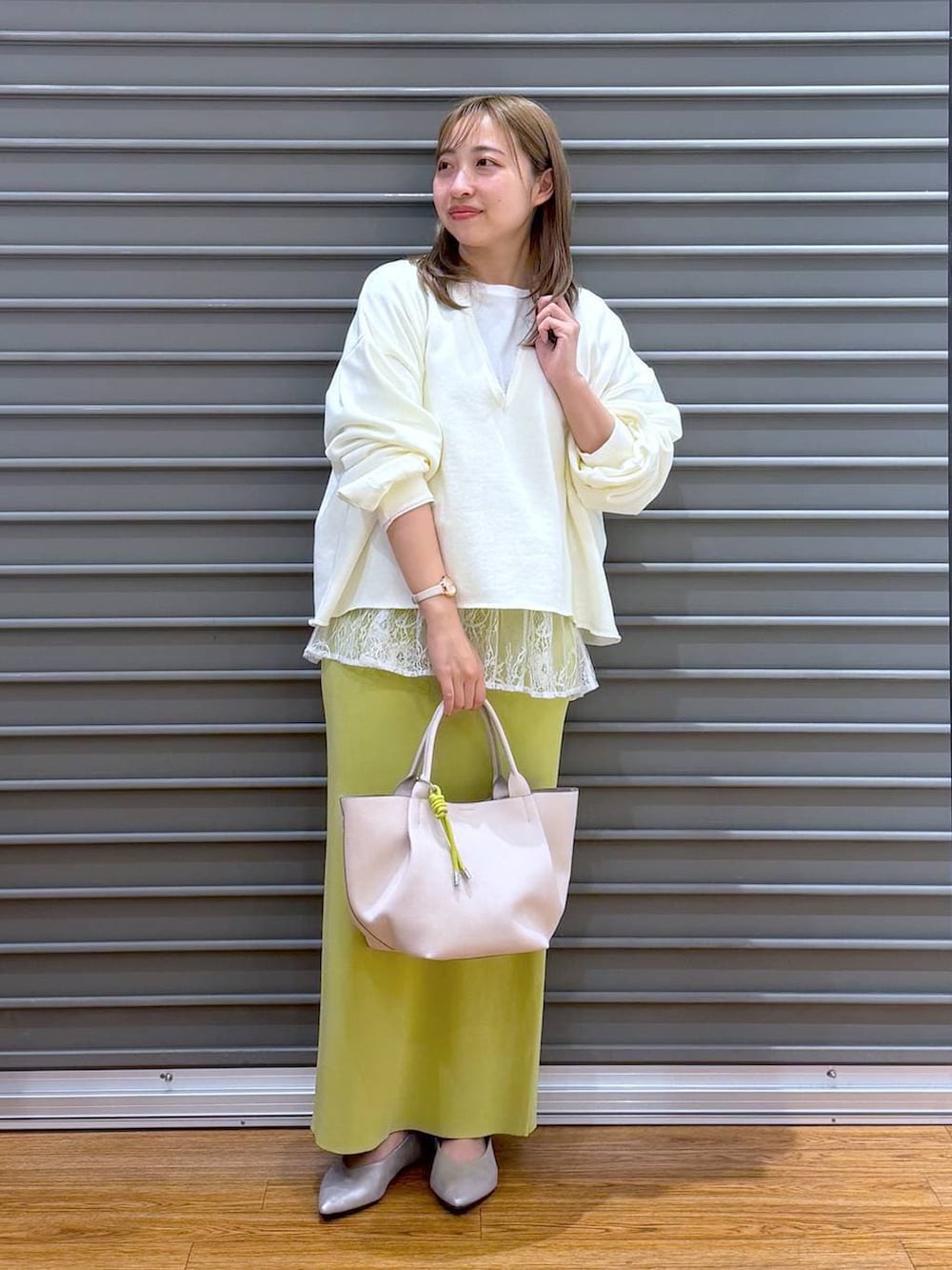 グリーン系のスカート、ホワイト系のTシャツ/カットソー、シルバー系のパンプスを着用したレディースの冬コーディネートの4枚目の写真