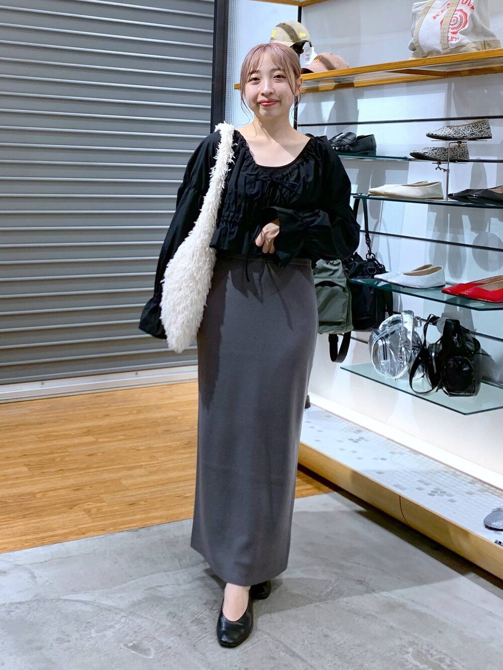 ホワイト系のショルダーバッグ、ブラック系のパンプス、グレー系のスカートを着用したレディースの秋コーディネートの5枚目の写真