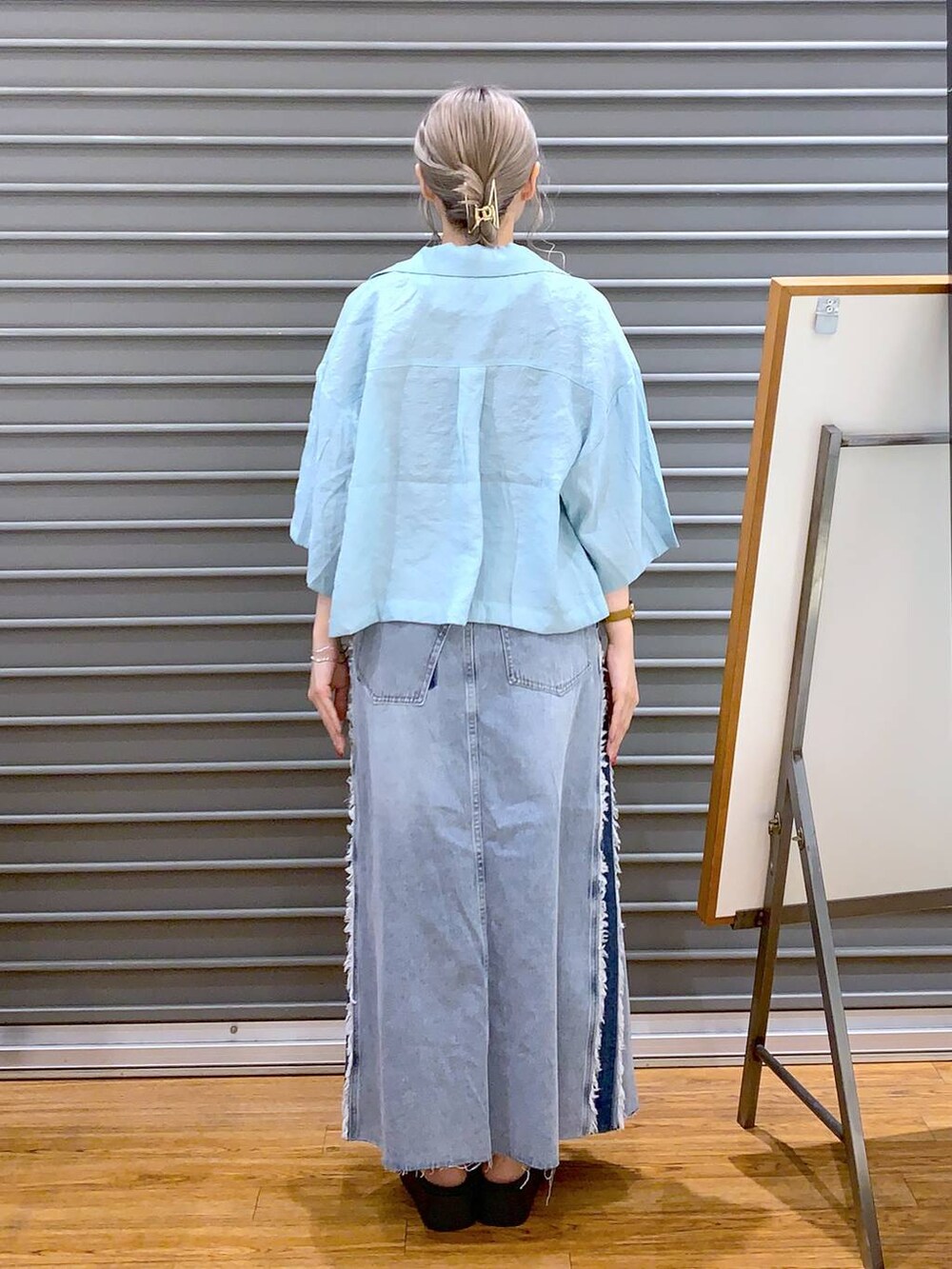 グレー系のタンクトップ、グレー系のショルダーバッグ、ホワイト系のサンダルを着用したレディースの夏コーディネートの2枚目の写真