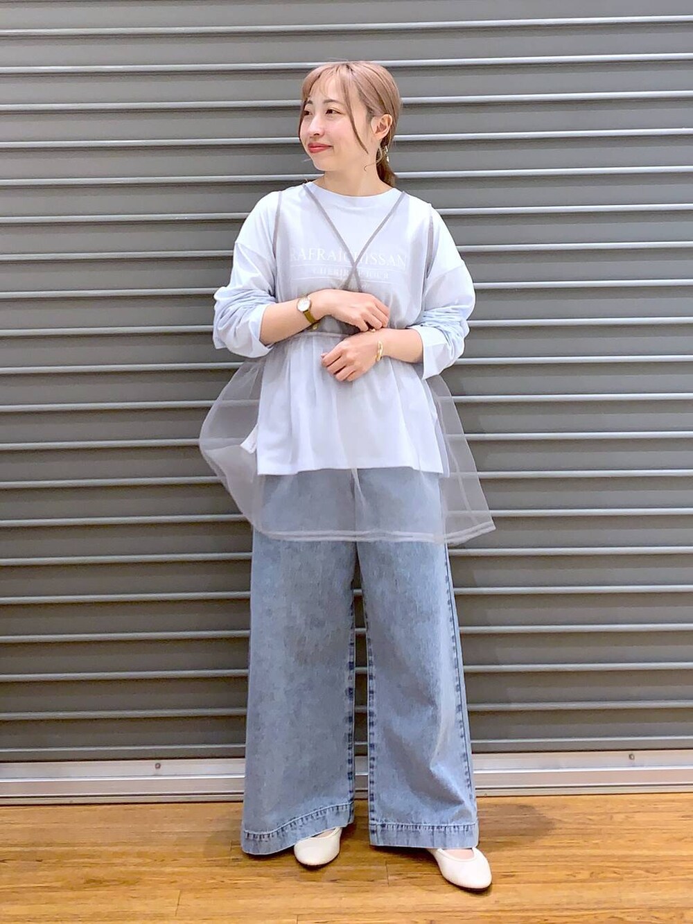 ブルー系のデニムパンツ、ホワイト系のバレエシューズ、イエロー系のショルダーバッグを着用したレディースの春コーディネートの4枚目の写真