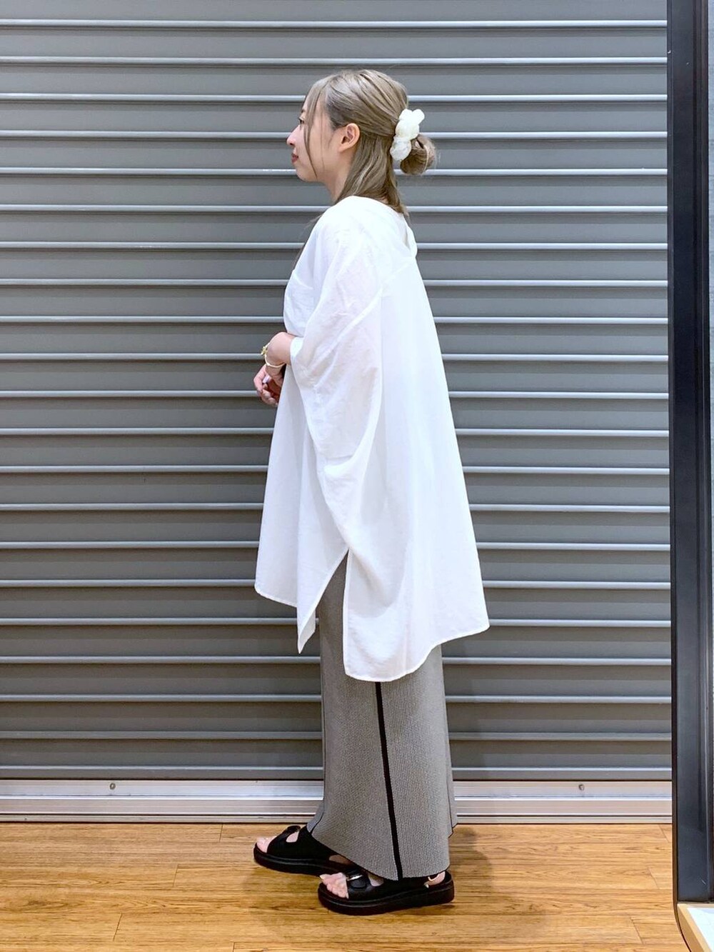 ホワイト系のTシャツ/カットソー、ブラック系のスカート、ブラック系のサンダルを着用したレディースの夏コーディネートの3枚目の写真