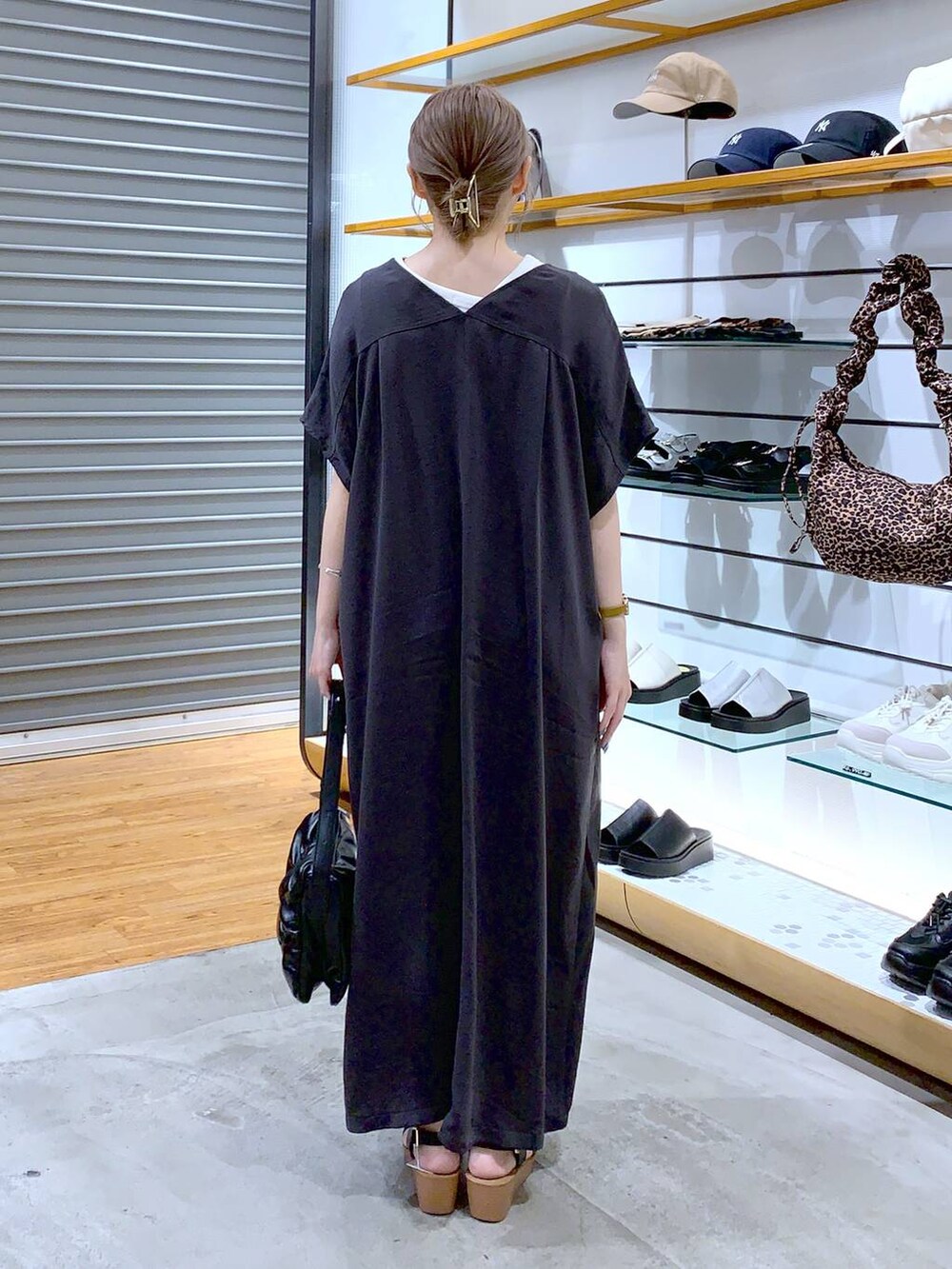 ブラック系のショルダーバッグ、グレー系のワンピース、ブラック系のサンダルを着用したレディースの夏コーディネートの2枚目の写真