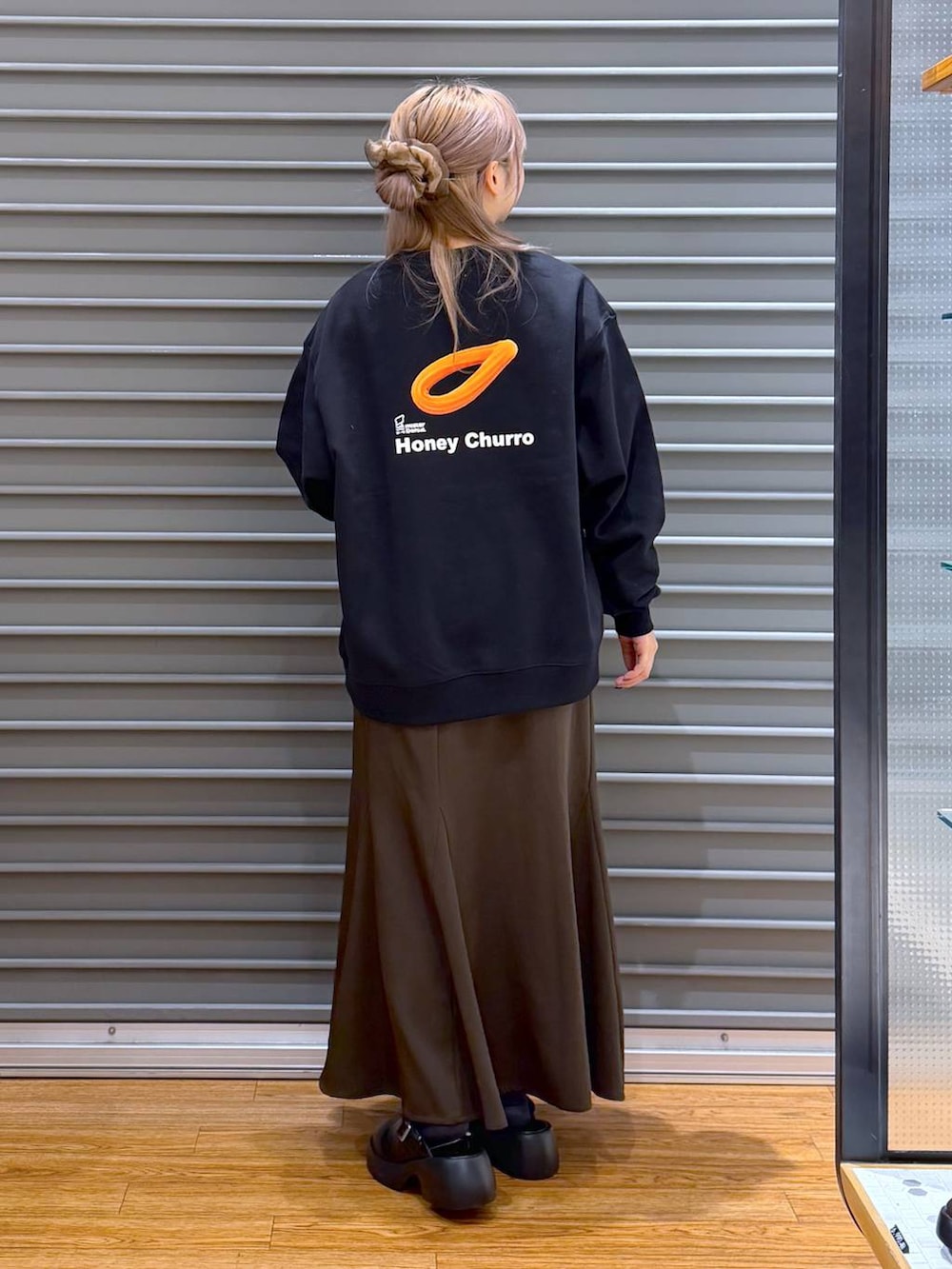 ブラック系のサンダル、ブラウン系のスカート、ブラック系のスウェットを着用したレディースの冬コーディネートの2枚目の写真