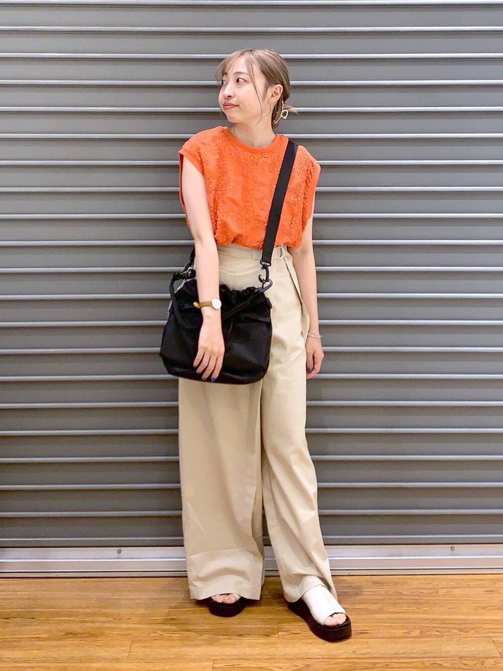 ブラック系のショルダーバッグ、オレンジ系のTシャツ/カットソー、ホワイト系のその他パンツを着用したレディースの夏コーディネートの3枚目の写真