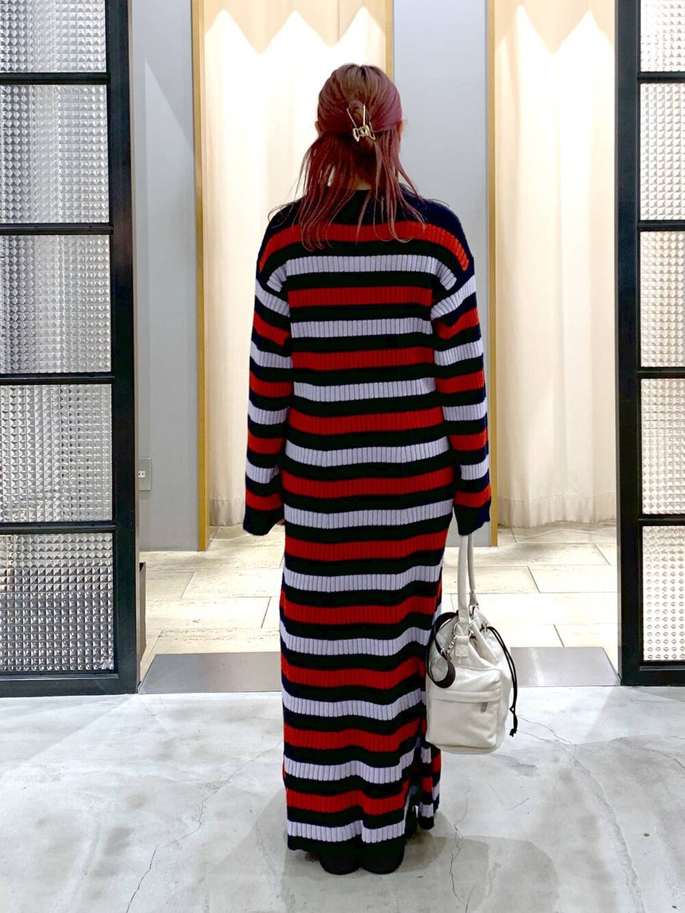 ブラック系のブーツ、ホワイト系のショルダーバッグ、その他のワンピースを着用したレディースの秋コーディネートの2枚目の写真