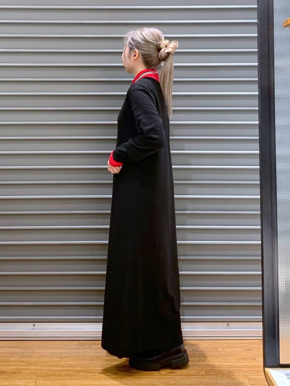 ブラック系のショルダーバッグ、ブラック系のブーツ、ブラック系のワンピースを着用したレディースの冬コーディネートの3枚目の写真