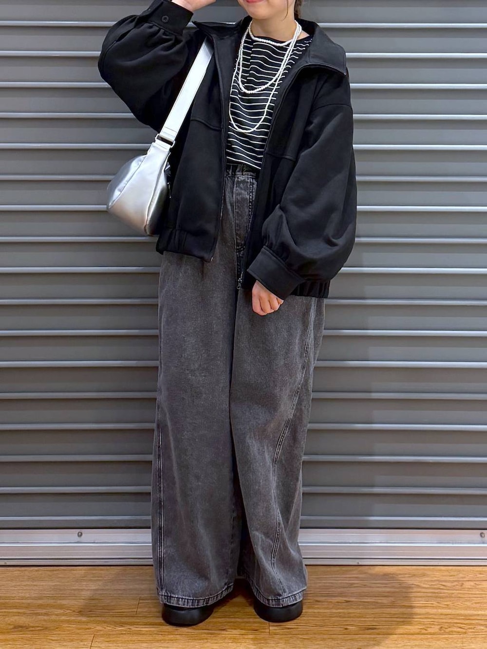 ブラック系のサンダル、グレー系のデニムパンツ、シルバー系のショルダーバッグを着用したレディースの冬コーディネートの7枚目の写真