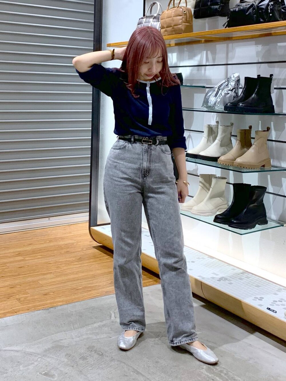 シルバー系のショルダーバッグ、シルバー系のパンプス、グレー系のデニムパンツを着用したレディースの秋コーディネートの3枚目の写真