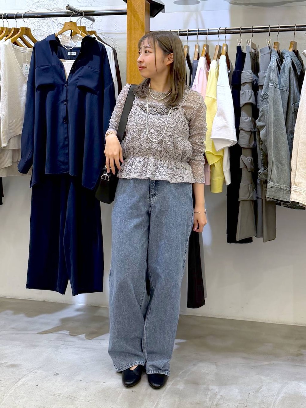 ブラック系のショルダーバッグ、ブルー系のデニムパンツ、グレー系のTシャツ/カットソーを着用したレディースの春コーディネートの4枚目の写真