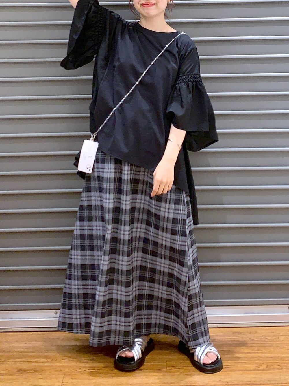 ブラック系のTシャツ/カットソー、シルバー系のサンダル、ホワイト系のスカートを着用したレディースの夏コーディネートの4枚目の写真