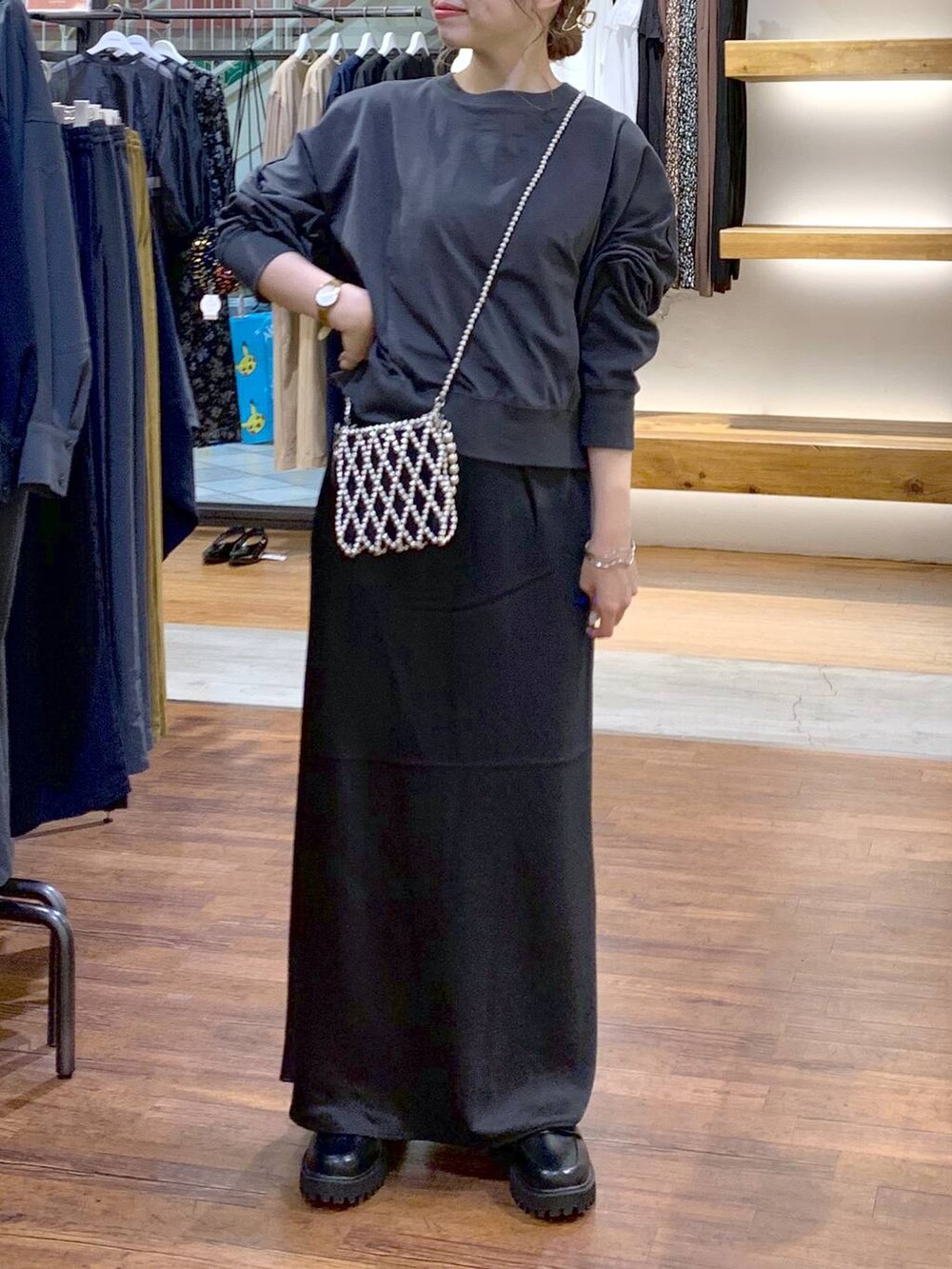 シルバー系のショルダーバッグ、ブラック系のスカート、ブラック系のローファーを着用したレディースの秋コーディネートの4枚目の写真