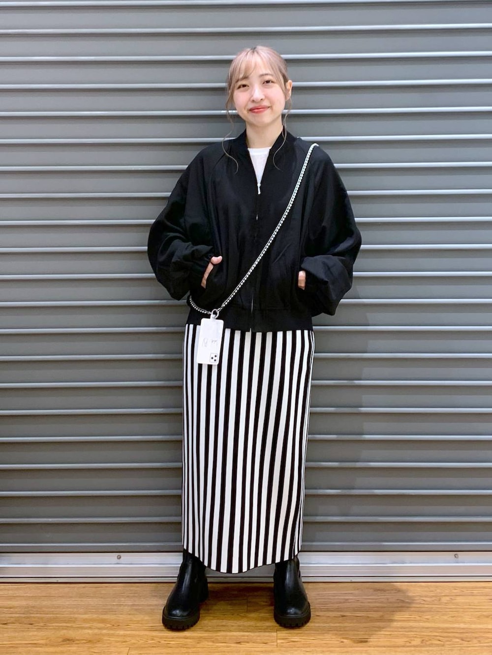 ブラック系のブルゾン、ブラック系のスカート、ブラック系のブーツを着用したレディースの秋コーディネートの4枚目の写真