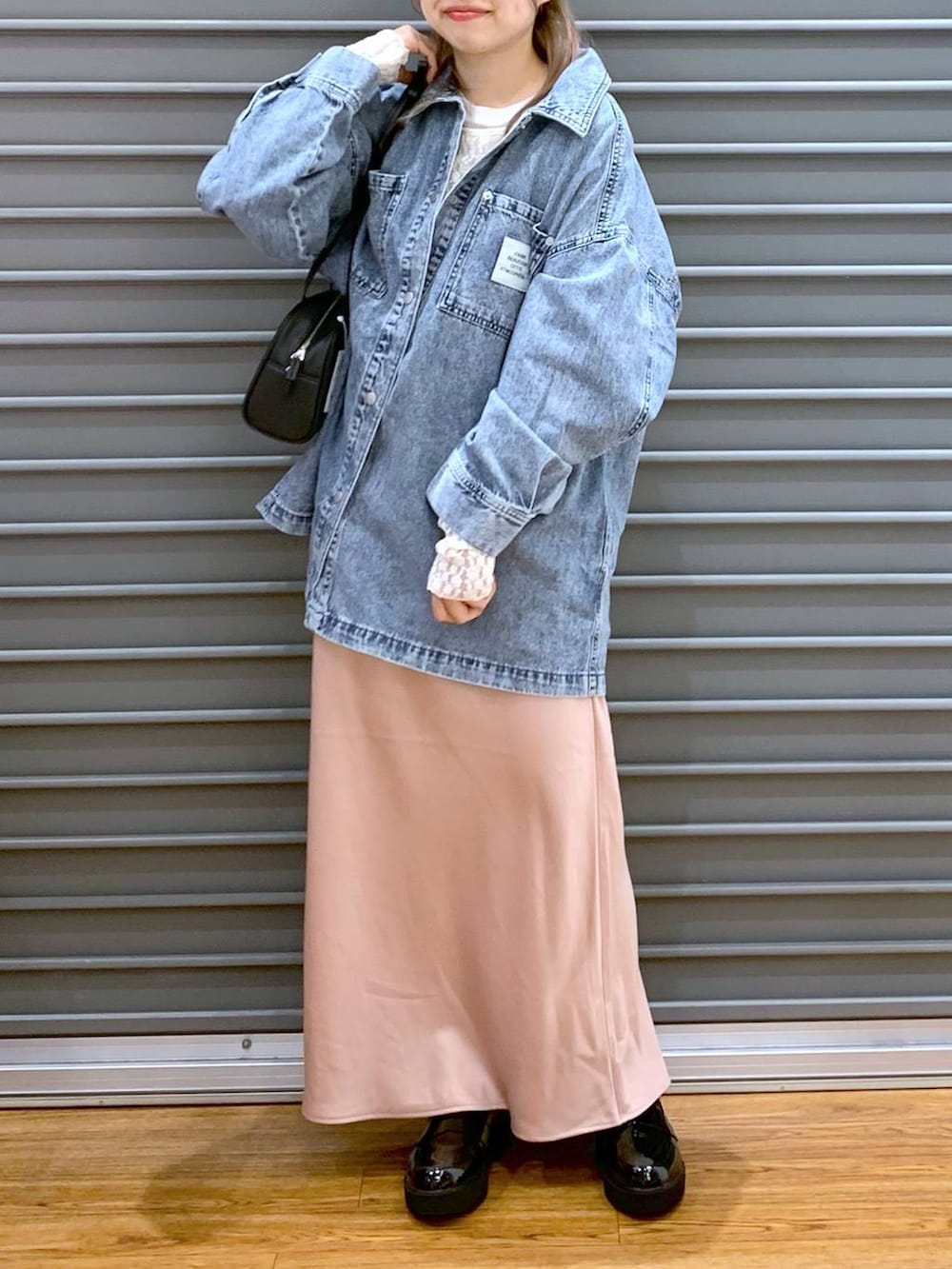 ピンク系のスカート、ブルー系のシャツ/ブラウス、ブラック系のショルダーバッグを着用したレディースの春コーディネートの4枚目の写真