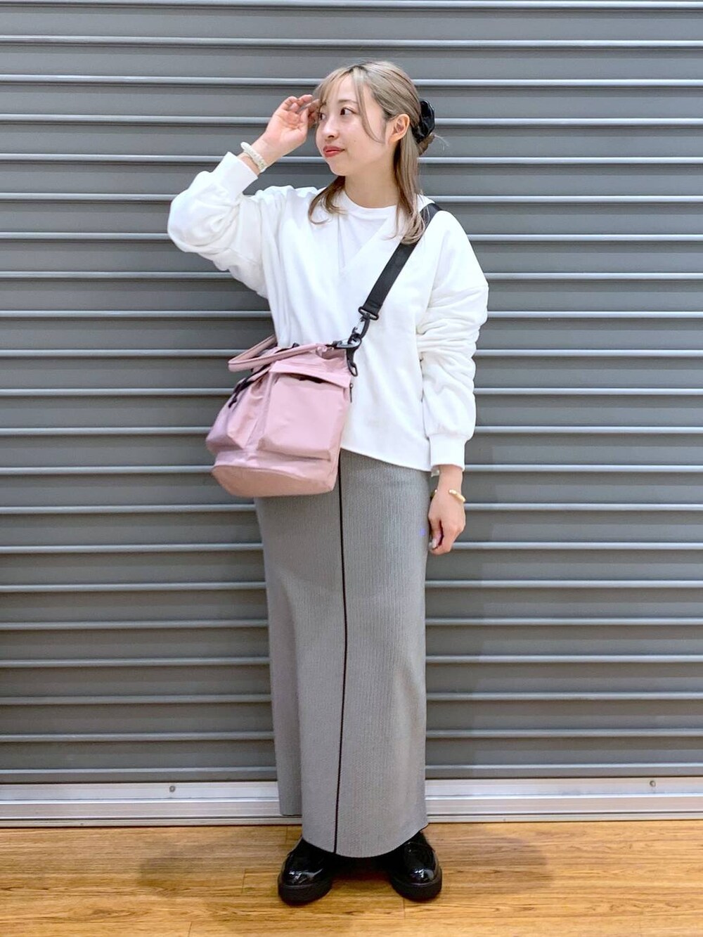 ピンク系のショルダーバッグ、ブラック系のローファー、ブラック系のスカートを着用したレディースの春コーディネートの7枚目の写真