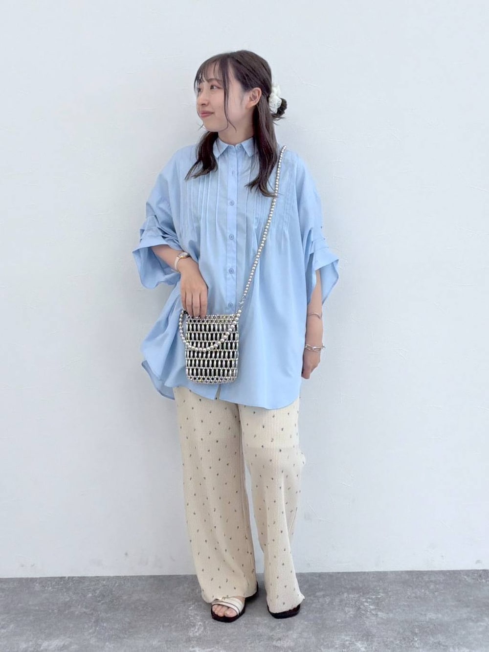 ベージュ系のその他パンツ、シルバー系のショルダーバッグ、ブルー系のシャツ/ブラウスを着用したレディースの夏コーディネートの5枚目の写真