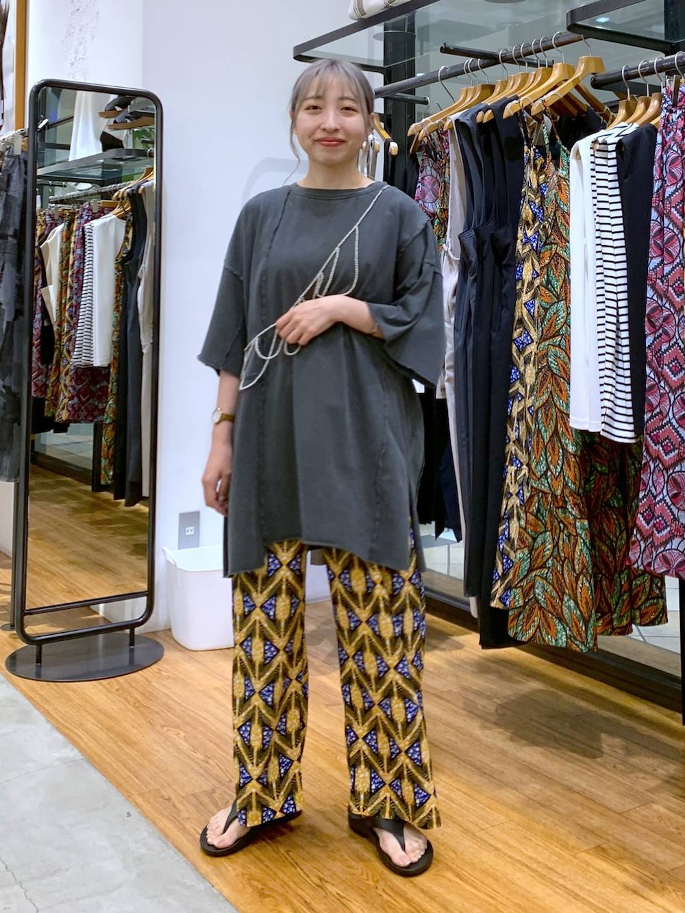 ブラック系のサンダル、グレー系のチュニック、オレンジ系のその他パンツを着用したレディースの夏コーディネートの5枚目の写真