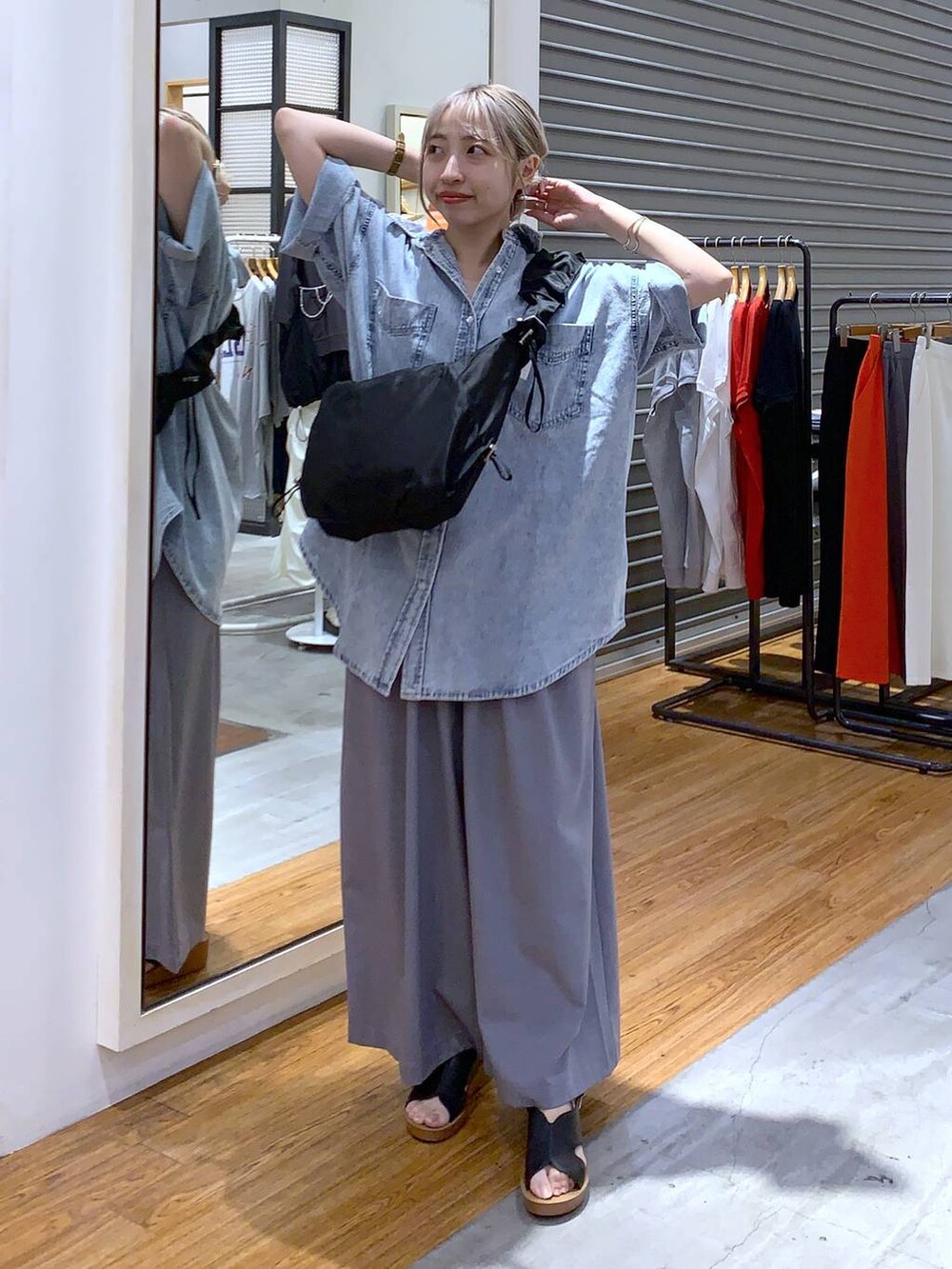 ブルー系のシャツ/ブラウス、ブラック系のサンダル、グレー系のスラックスを着用したレディースの夏コーディネートの4枚目の写真