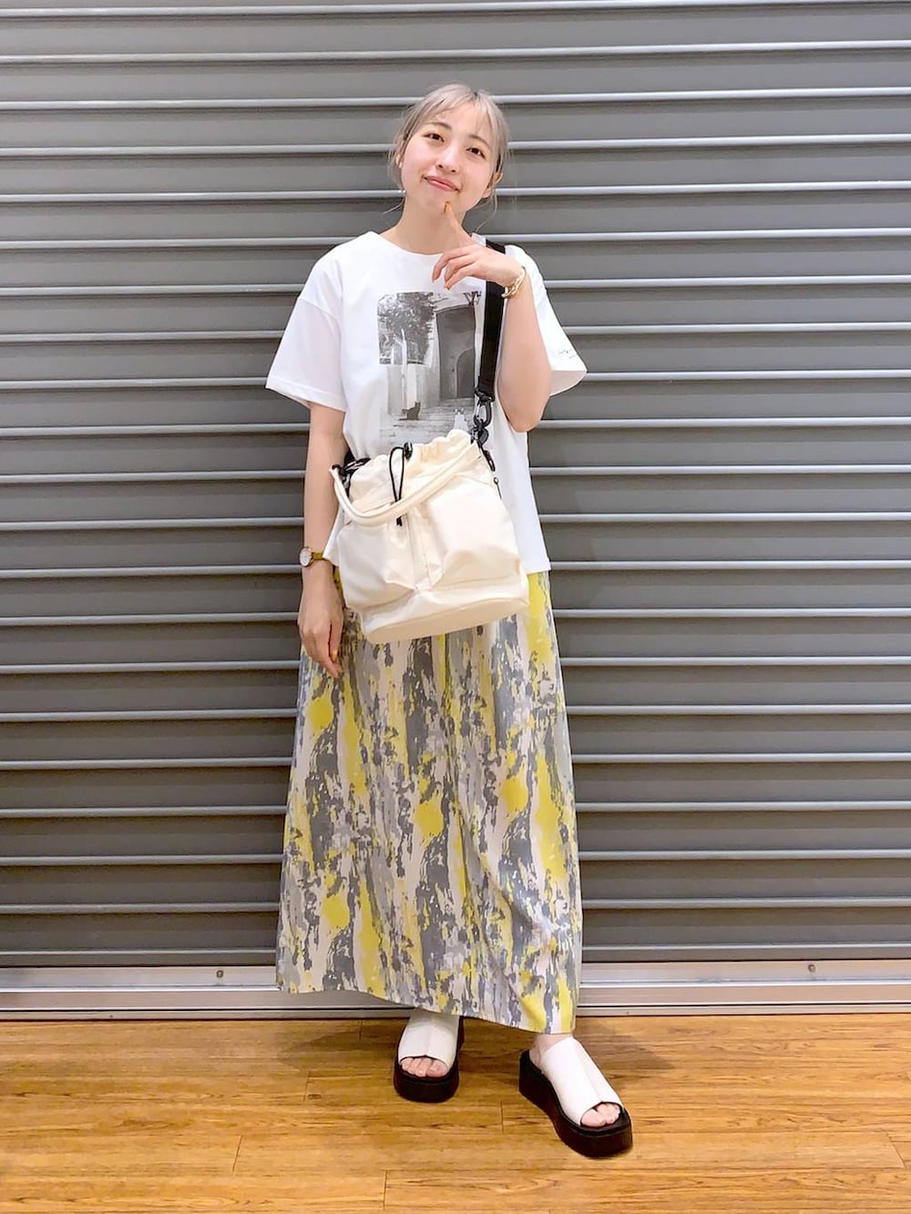 イエロー系のワンピース、ホワイト系のショルダーバッグ、ホワイト系のサンダルを着用したレディースの春コーディネートの4枚目の写真