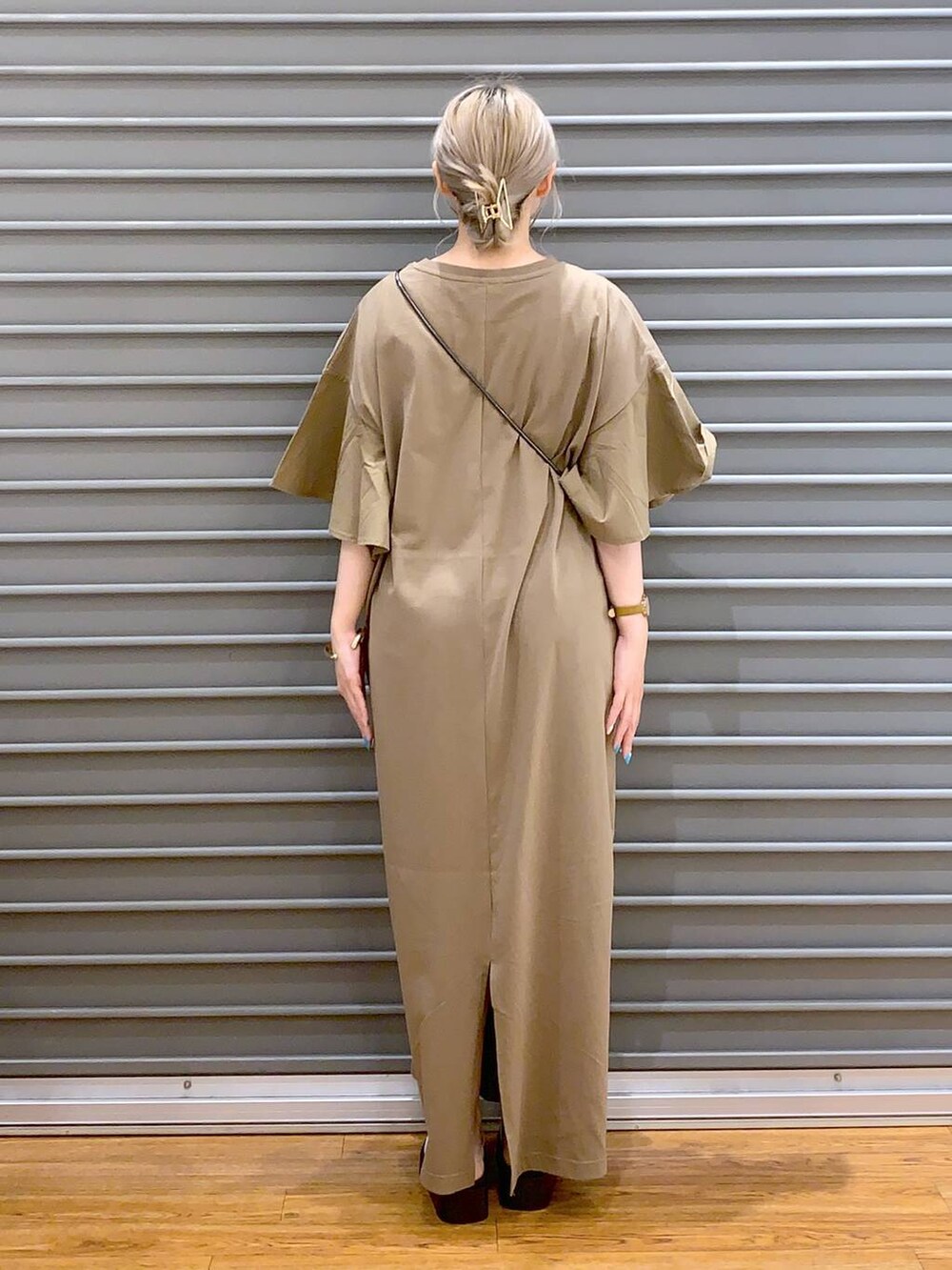 ブラック系のショルダーバッグ、ホワイト系のサンダル、ベージュ系のワンピースを着用したレディースの夏コーディネートの2枚目の写真