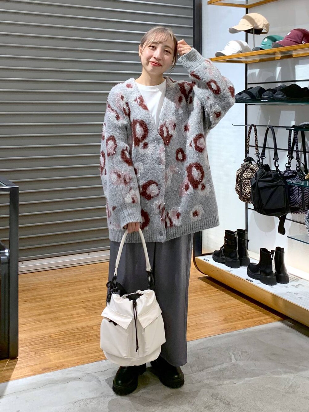 ホワイト系のショルダーバッグ、ブラック系のブーツ、ブラック系のスカートを着用したレディースの冬コーディネートの5枚目の写真