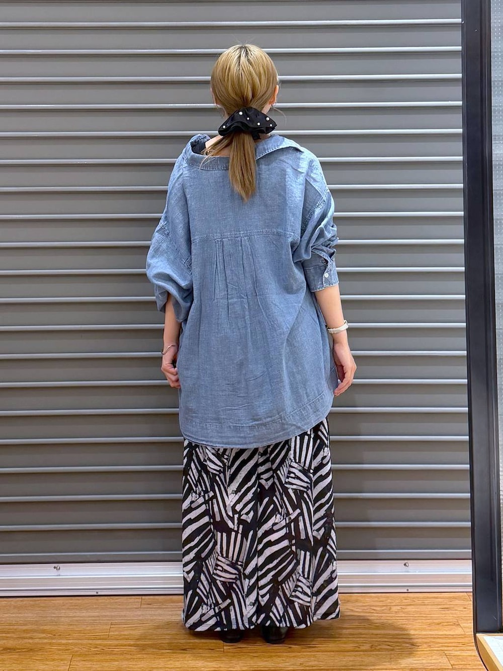 ブラック系のその他パンツ、ブラック系のパンプス、ブルー系のシャツ/ブラウスを着用したレディースの春コーディネートの2枚目の写真
