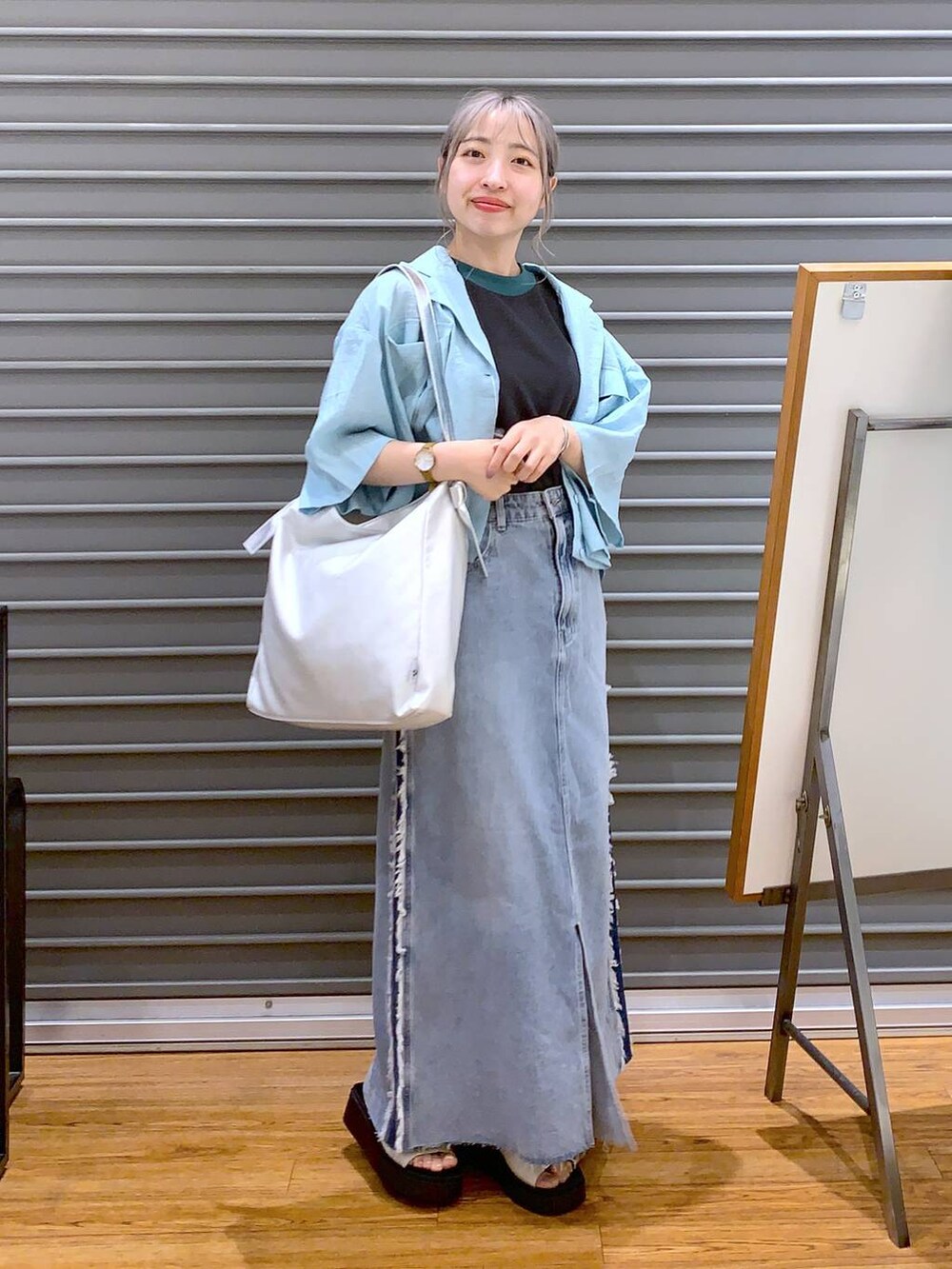 グレー系のタンクトップ、グレー系のショルダーバッグ、ホワイト系のサンダルを着用したレディースの夏コーディネートの7枚目の写真