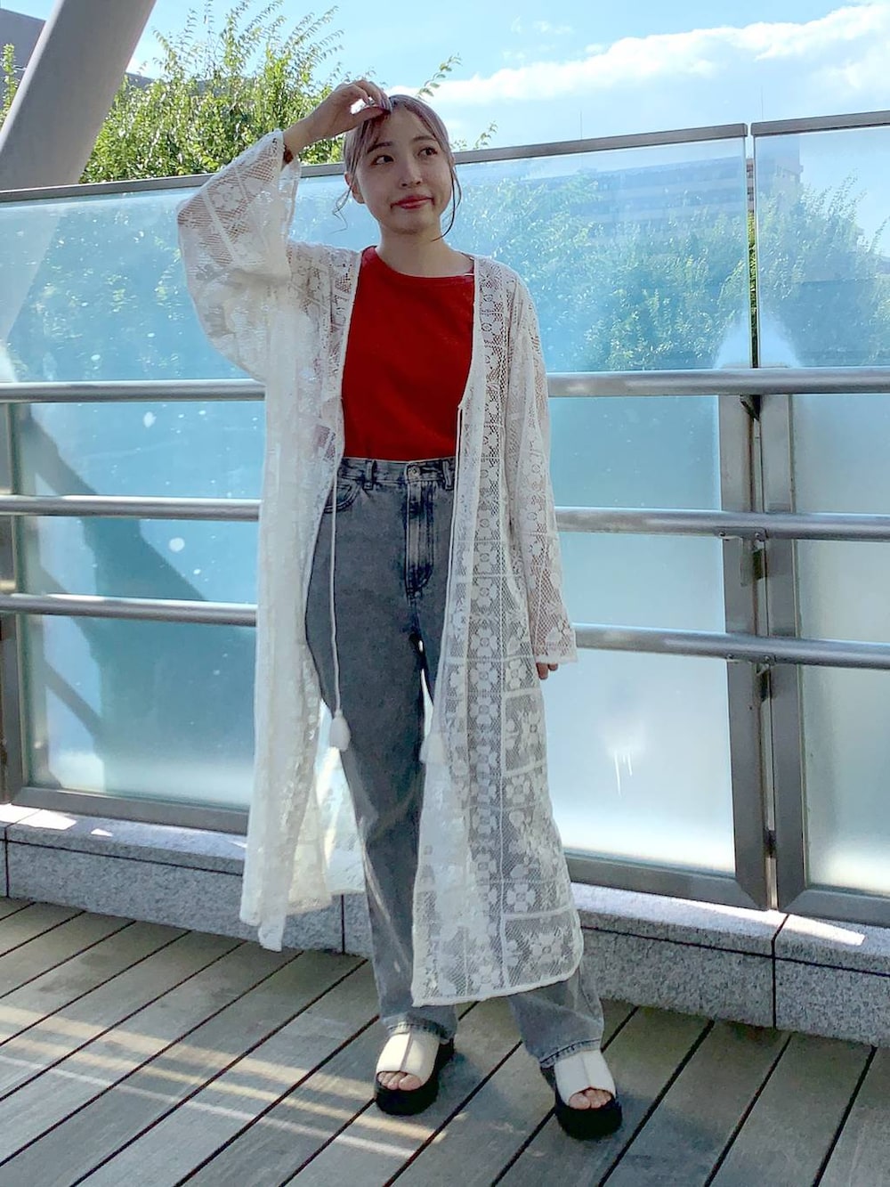 ホワイト系のワンピース、ホワイト系のサンダル、オレンジ系のタンクトップを着用したレディースの夏コーディネートの4枚目の写真