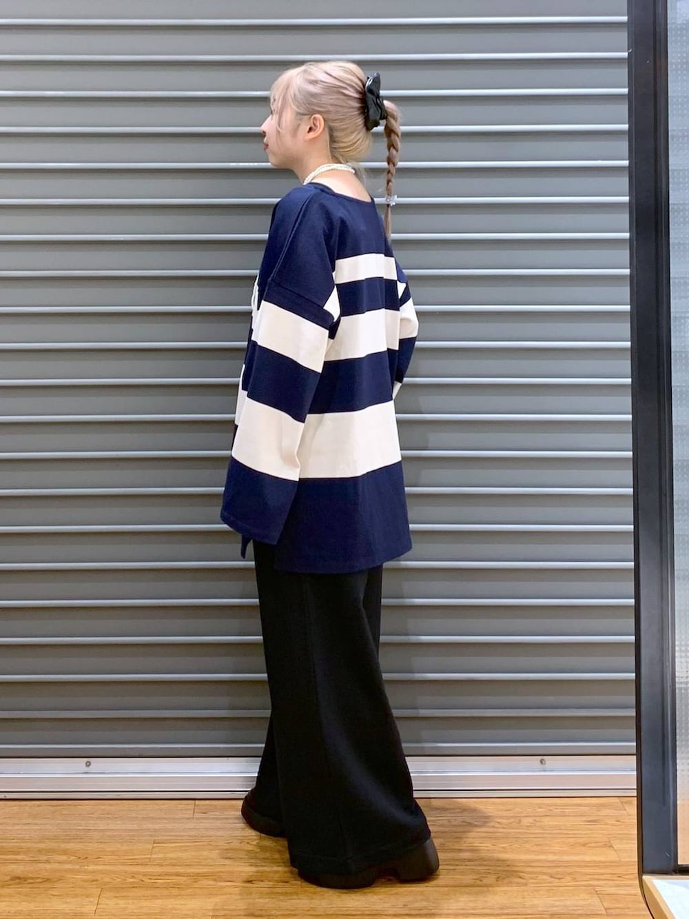 ブラック系のスウェットパンツ、ブラック系のサンダル、ブルー系のTシャツ/カットソーを着用したレディースの秋コーディネートの3枚目の写真