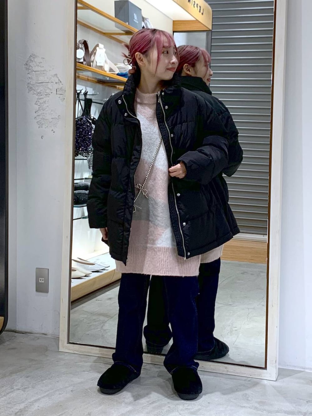 ブルー系のデニムパンツ、ブラック系のダウンジャケット/コート、ブラック系のその他シューズを着用したレディースの冬コーディネートの4枚目の写真