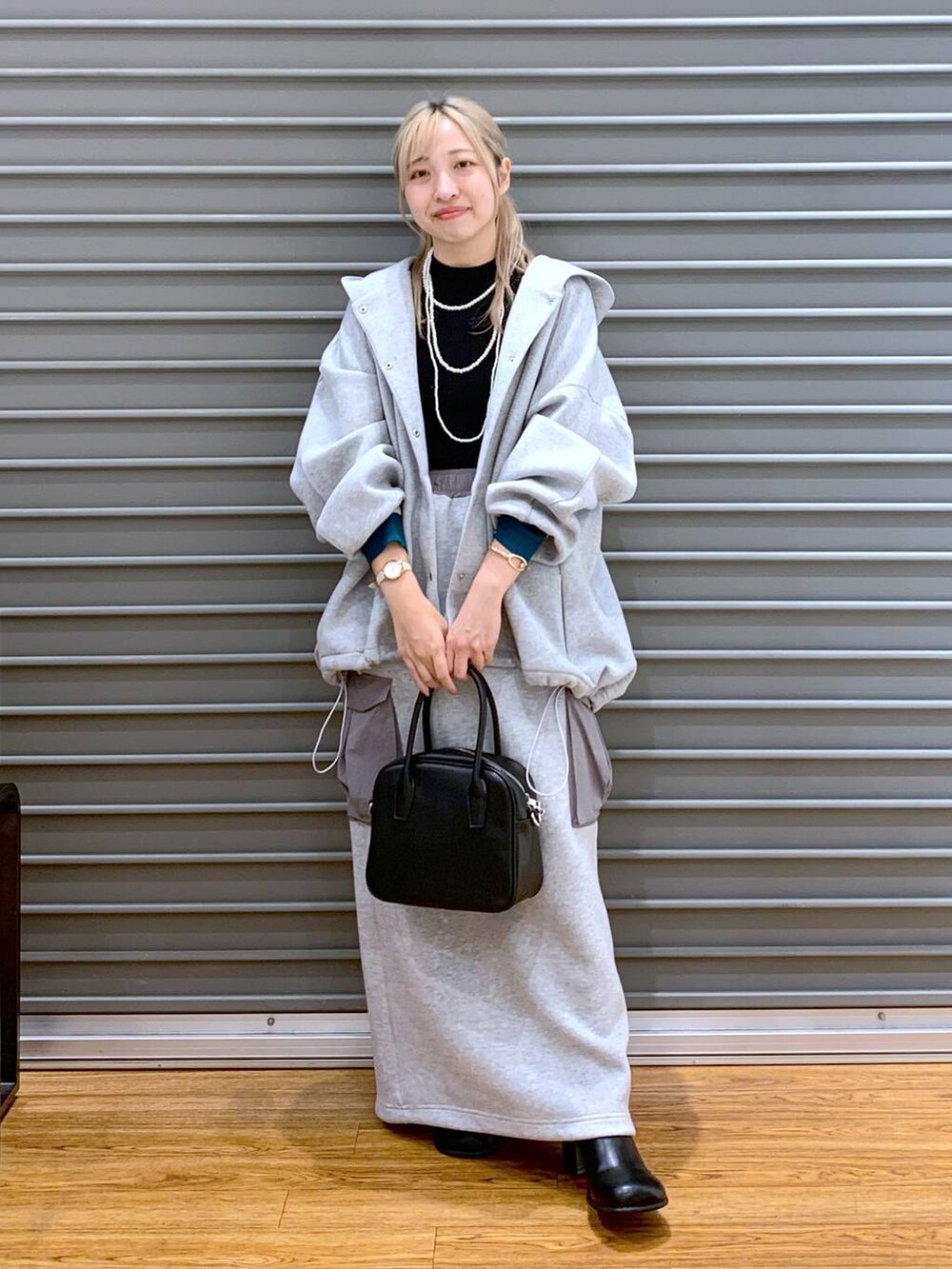 グレー系のブルゾン、ブラック系のニット/セーター、グレー系のスカートを着用したレディースの秋コーディネートの8枚目の写真
