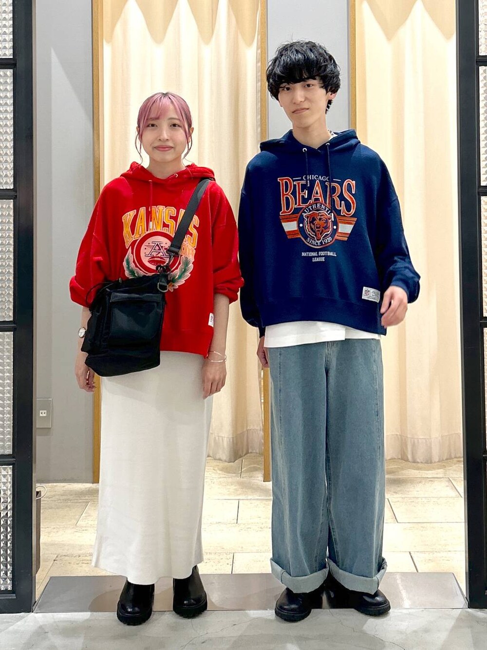 ブラック系のショルダーバッグ、ブルー系のデニムパンツ、ブラック系のブーツを着用したレディースの秋コーディネートの4枚目の写真