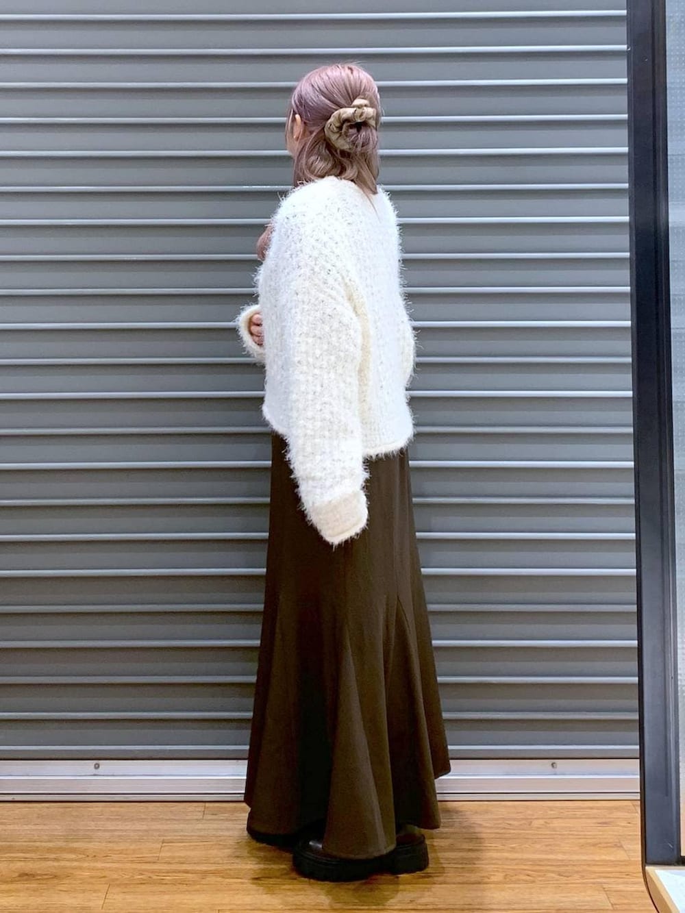 ブラウン系のブーツ、ホワイト系のニット/セーター、ブラック系のショルダーバッグを着用したレディースの冬コーディネートの3枚目の写真