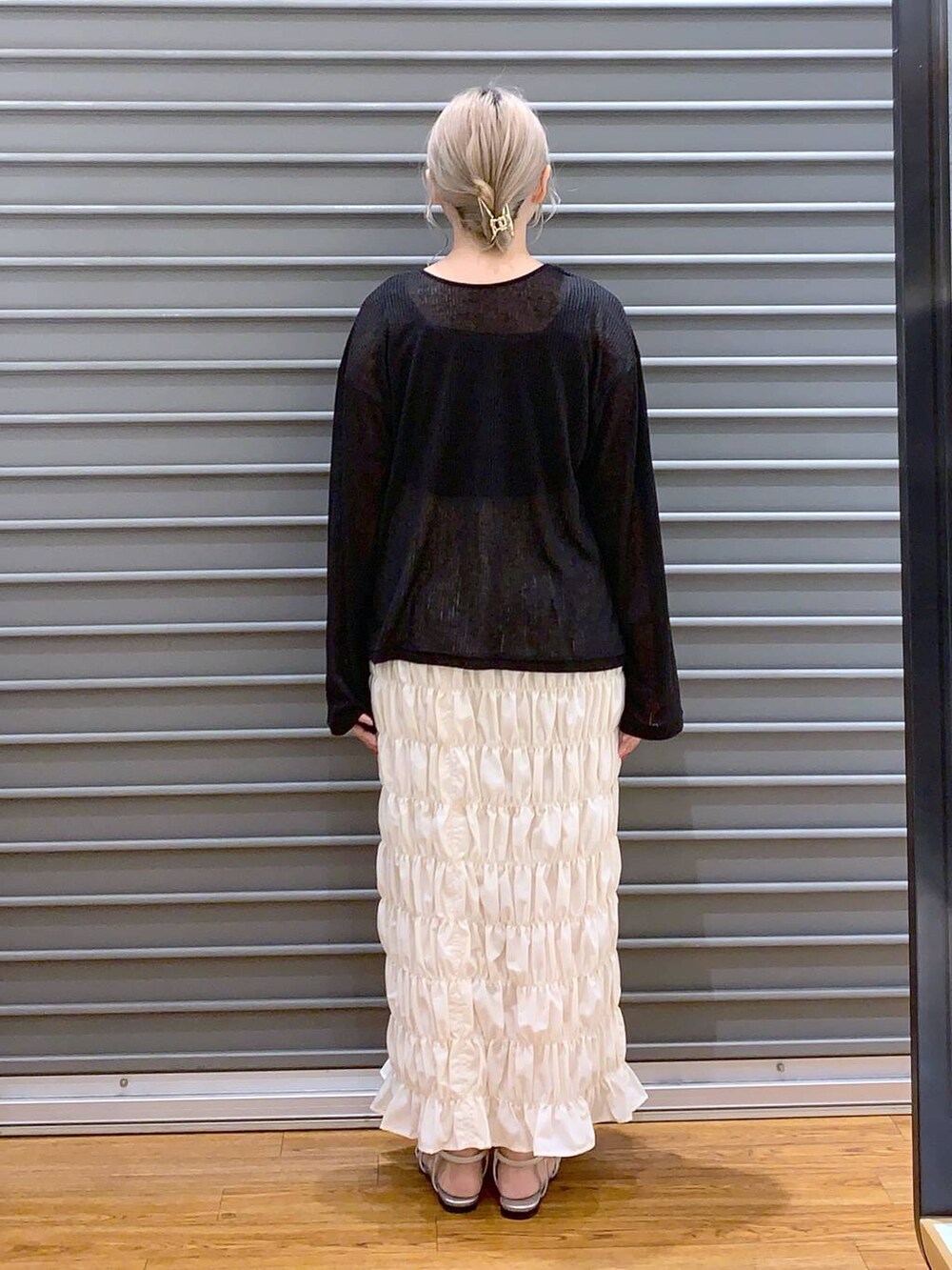 シルバー系のサンダル、ブラック系のカーディガン/ボレロ、グレー系のショルダーバッグを着用したレディースの夏コーディネートの2枚目の写真