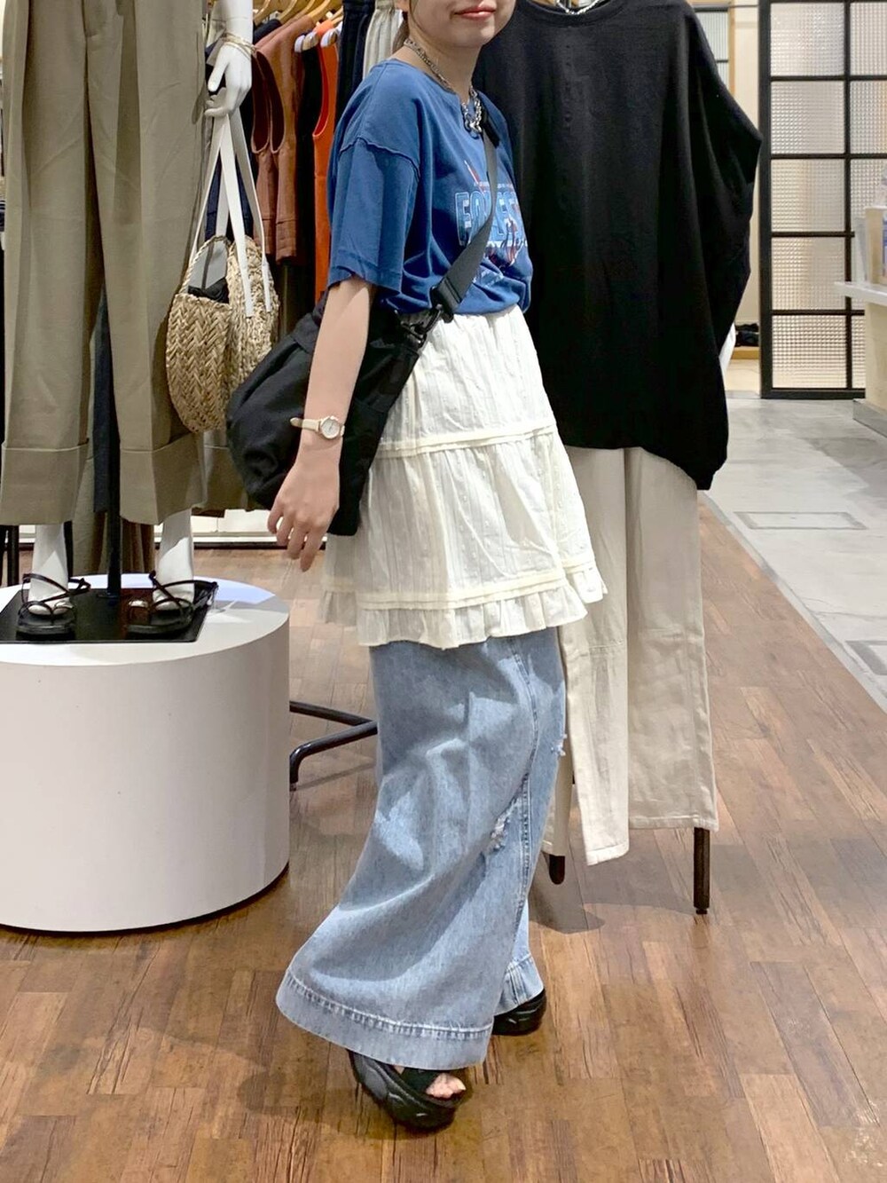 ブルー系のデニムパンツ、ブラック系のサンダル、ブラック系のショルダーバッグを着用したレディースの夏コーディネートの8枚目の写真