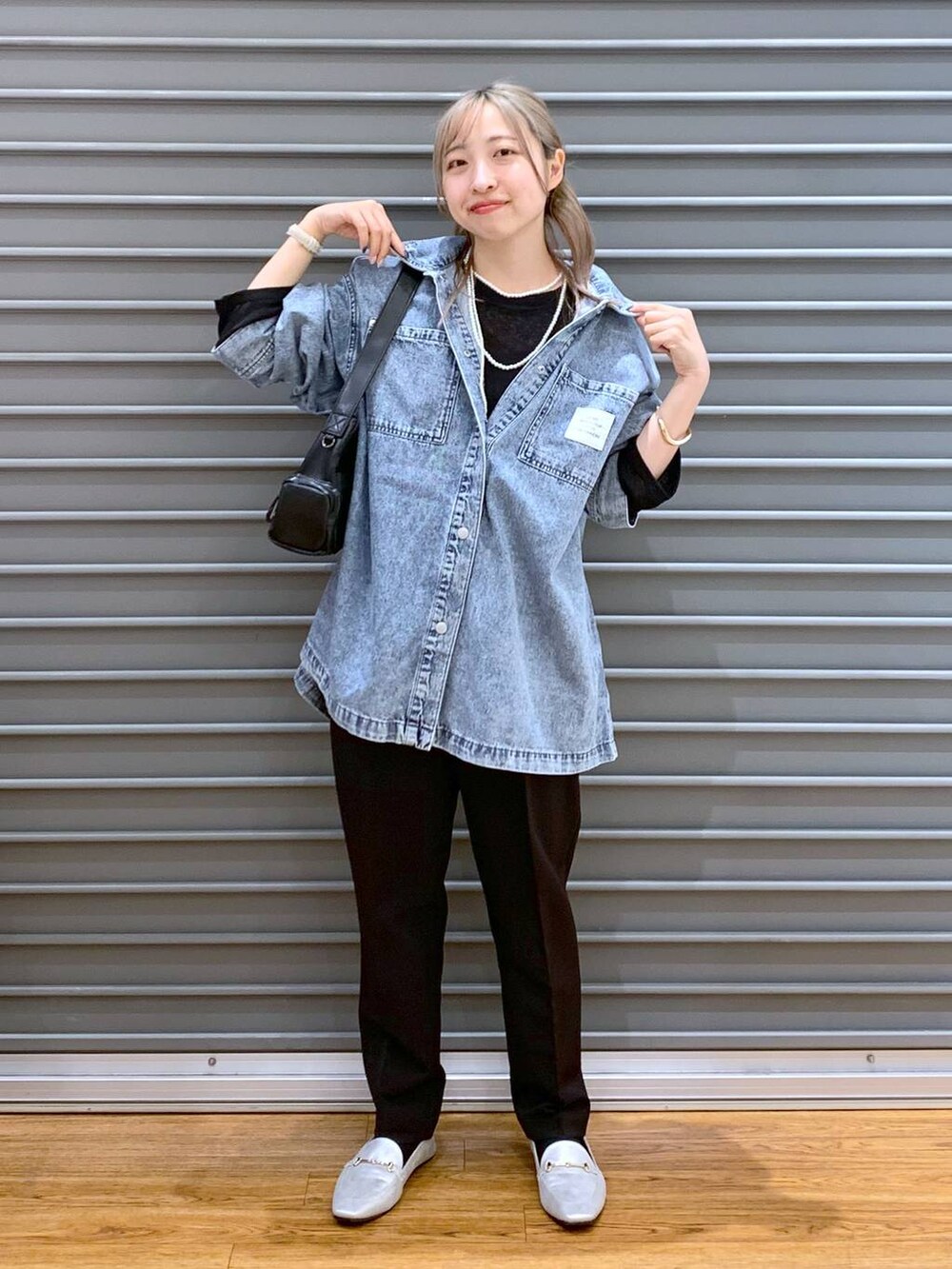 ブラック系のTシャツ/カットソー、ブラック系のスーツパンツ、シルバー系のローファーを着用したレディースの冬コーディネートの5枚目の写真