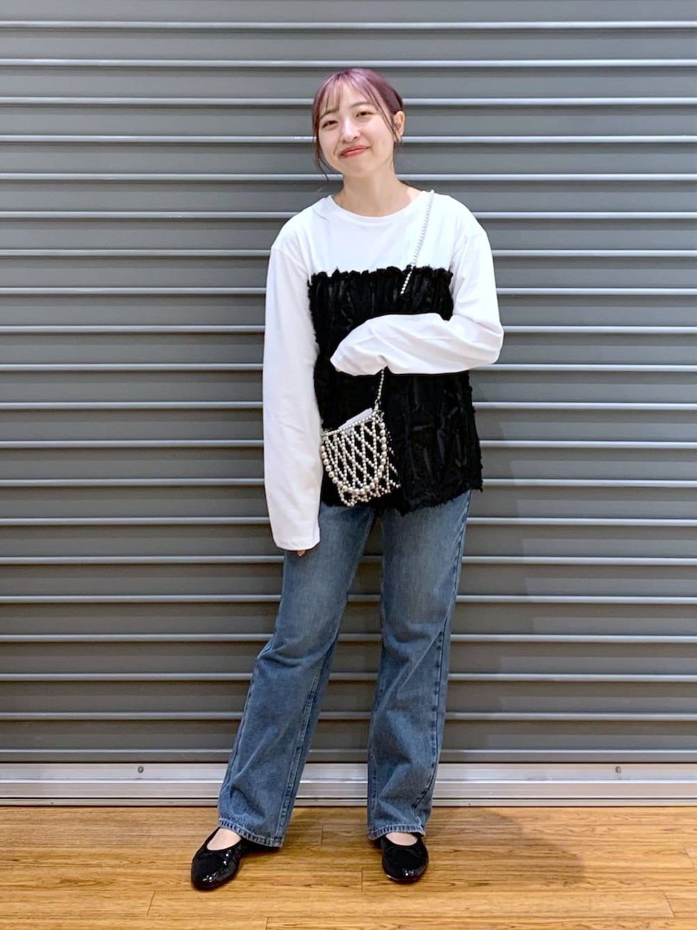 シルバー系のショルダーバッグ、ブルー系のデニムパンツ、ブラック系のバレエシューズを着用したレディースの秋コーディネートの4枚目の写真