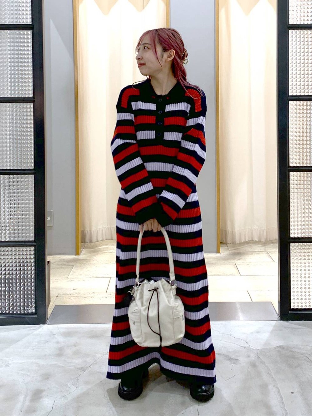 ブラック系のブーツ、ホワイト系のショルダーバッグ、その他のワンピースを着用したレディースの秋コーディネートの5枚目の写真